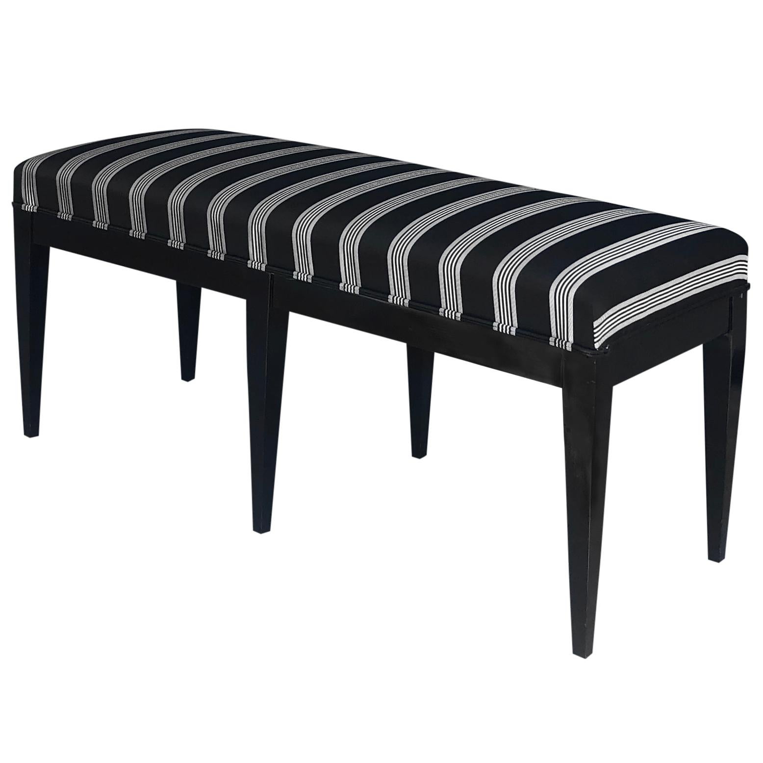 A vintage Mid-Century Modern Italian Neoclassical style ebonized bench made of hand crafted Giltwood, standing on six straight black wooden legs, in good condition. Newly upholstered in a black, white fabric. Wear consistent with age and use, circa