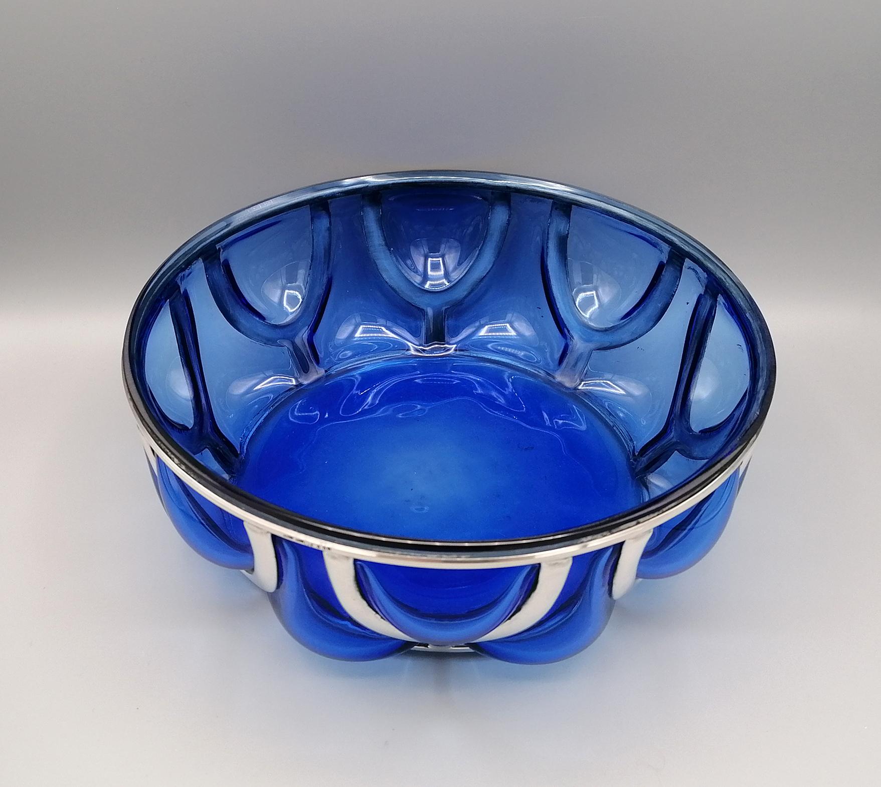 Blue Murano glass bowl embellished with a solid 800 silver cage.
Created by Florentine artists according to an ancient manufacturing tradition of the Italian Renaissance.
The silver strips are smooth so as not to overshadow the beauty of the red