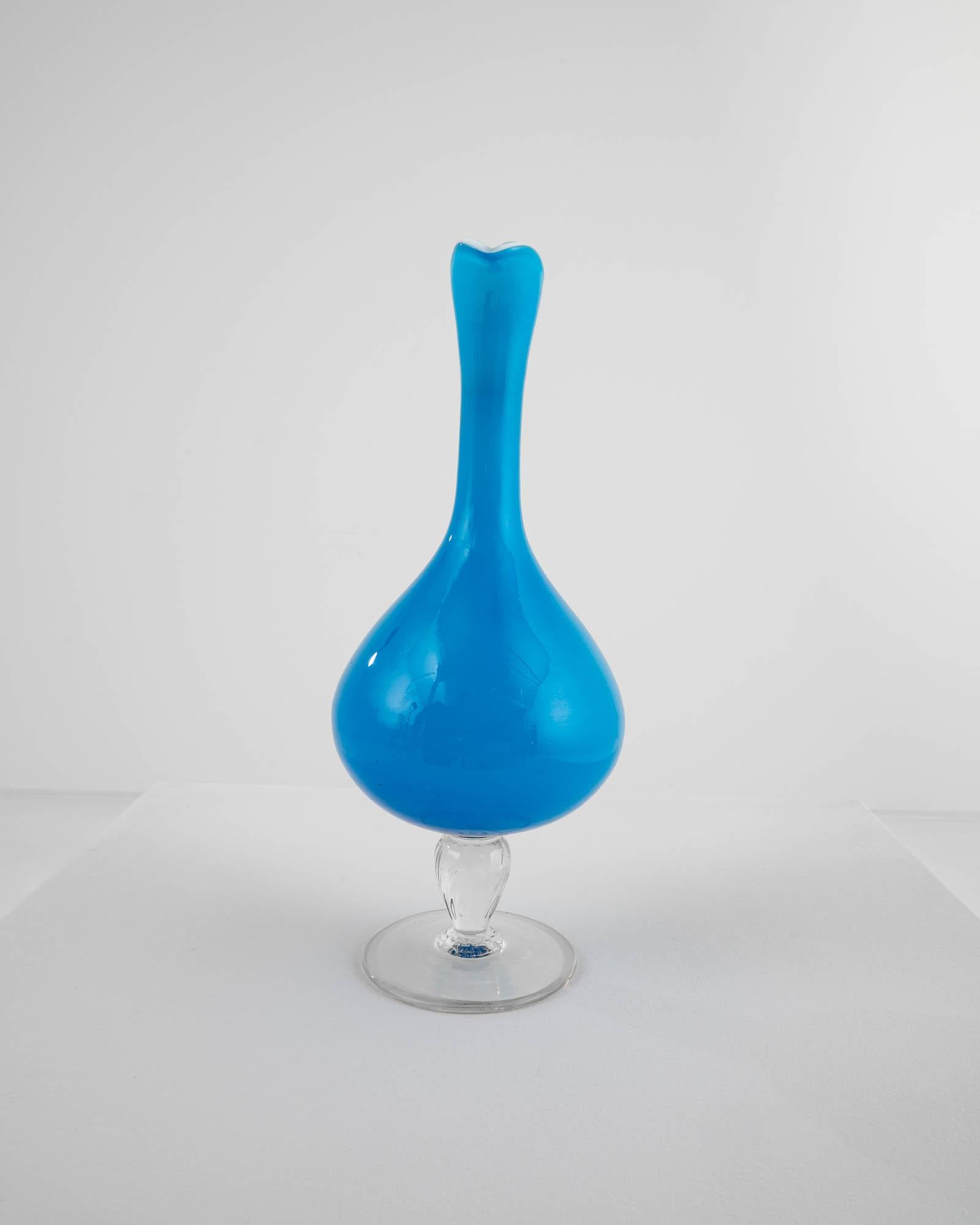 Romantic and striking, this glass vase offers a unique vintage accent. Made in Italy in the 1960s, the shape is elegant and piercing: a slender handle gracefully merges with the colored glass vessel. Beautifully crafted, the semi-translucent glass