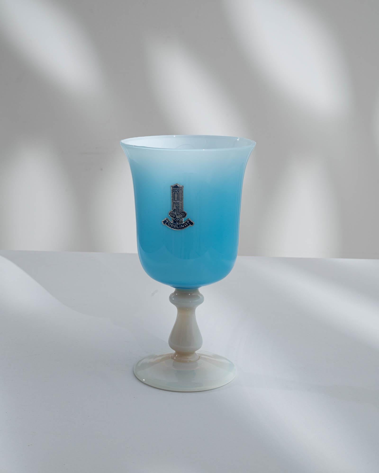 Crafted with finesse, this 20th-century Italian blue glass vase is a testament to Murano's renowned artistry. The vase features a stunning blue satin glass body, exuding an air of refinement and sophistication. Its white stem adds a contrasting