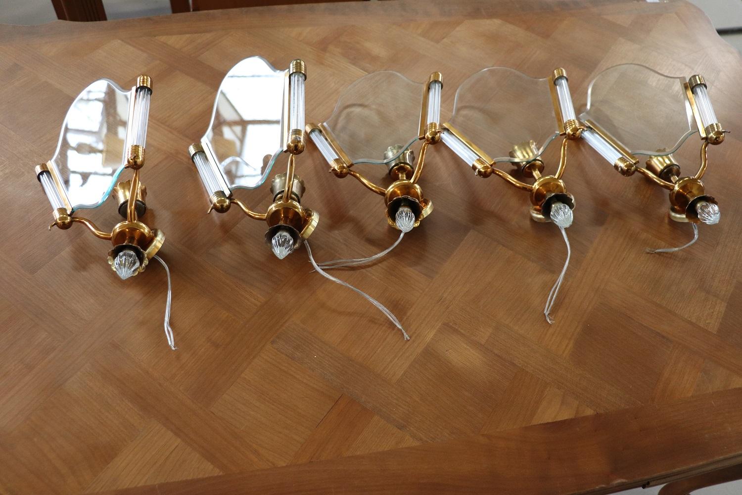 Beautiful and refined Italian set of five wall lights or sconces with one light. Made in brass with transparent glass. Very decorative for your wall. Some signs of the passage of time in brass, New electrical system wires.