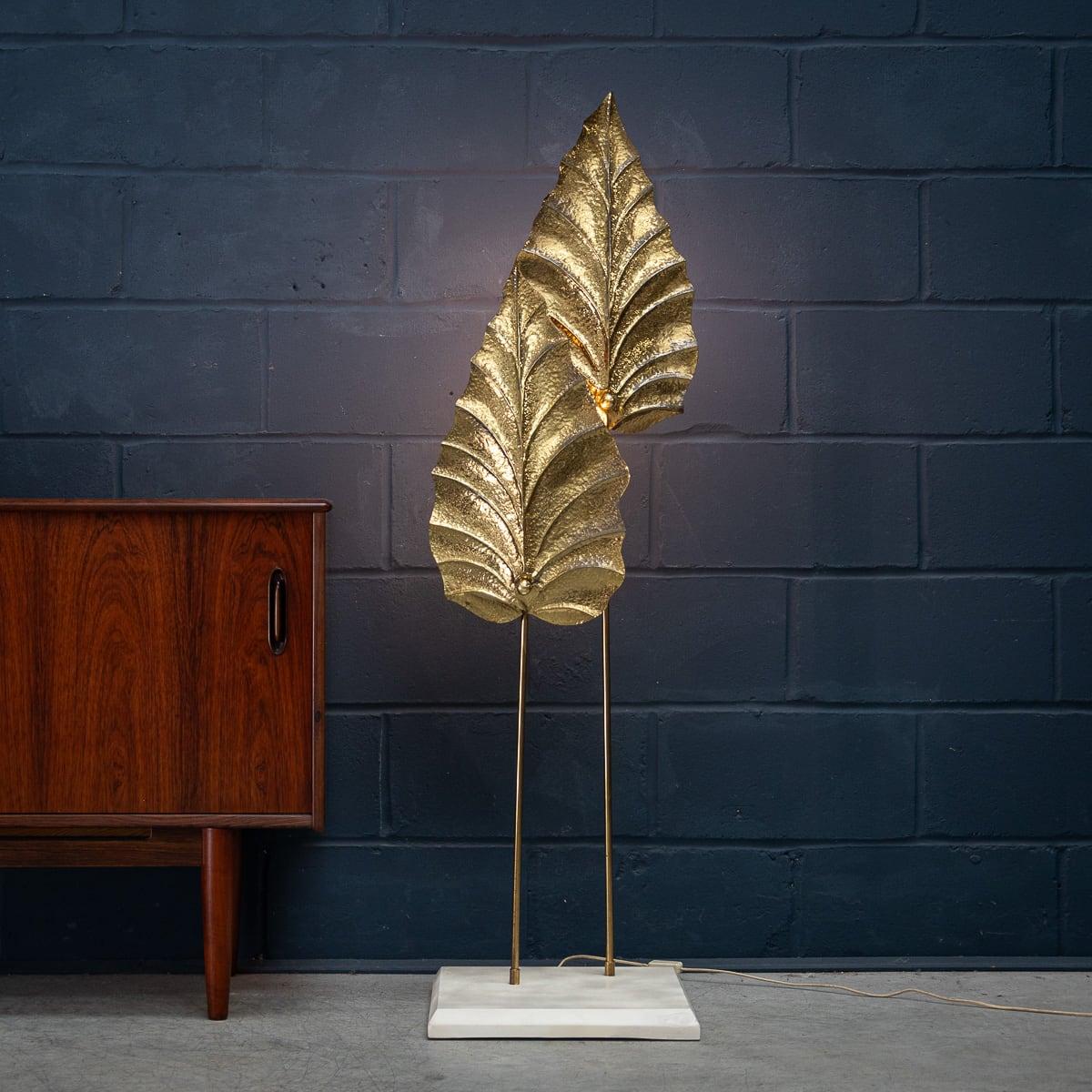 Un remarquable lampadaire à deux feuilles, inspiré du style de Tommaso Barbi, combine magnifiquement l'élégance naturelle avec une touche glamour. La structure de la lampe comporte deux grandes feuilles en laiton pressé qui captent et reflètent la