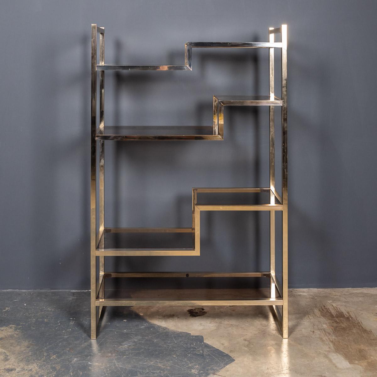 An elegant Italian made solid brass etagere display shelves, comprising of seven staggered, smoked glass shelves, of varying sizes, made and designed in the 1970's.

Measures: Height: 158cm
Width: 99cm
Depth: 37cm.