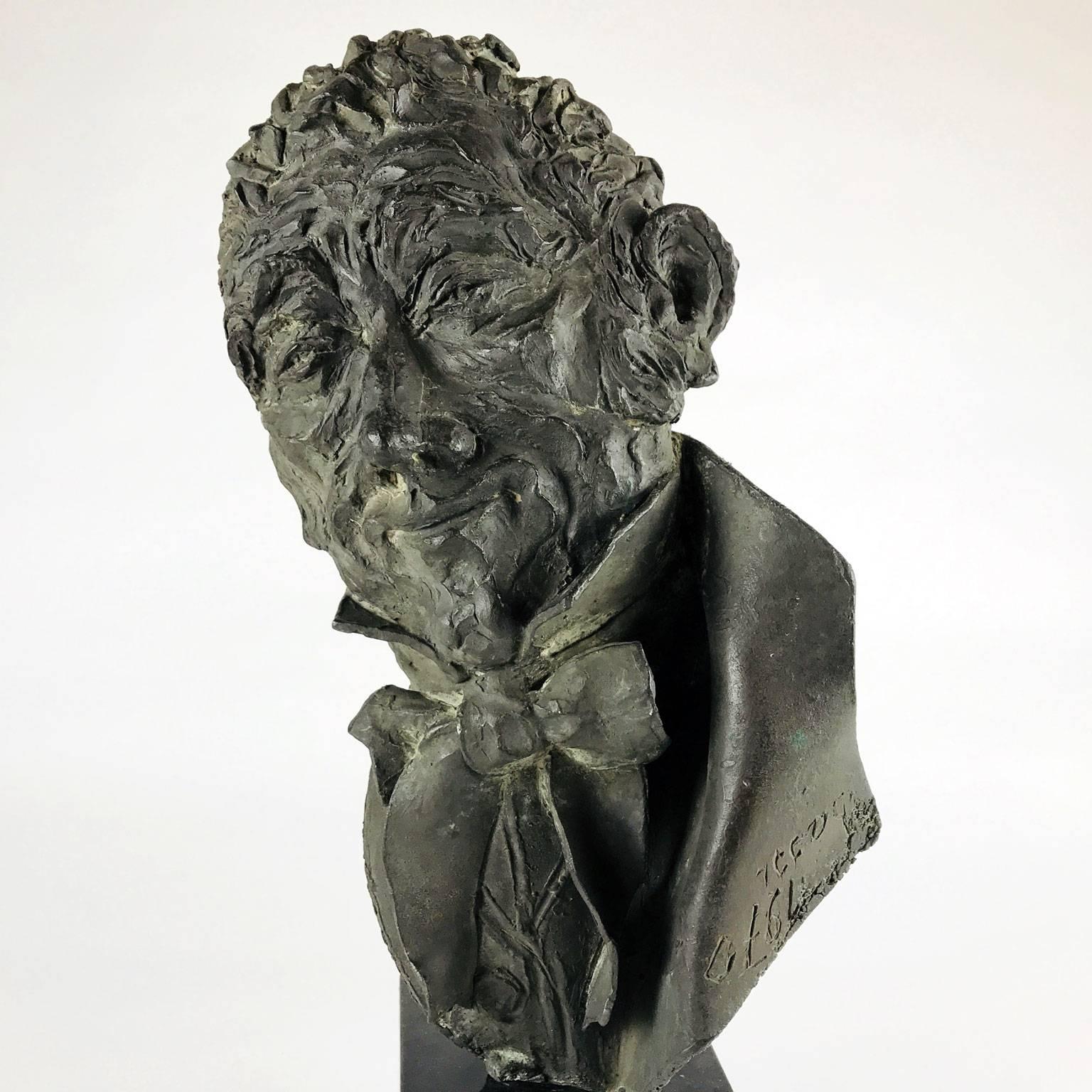 Antique Italian bronze sculpture of a smiling man, probably depicting the artist Alessandro Manzoni, with mocking look wearing a bowtie, signed and dated on the back coat collar Bassi, 1970, by the Italian artist Dora Bassi (1921-2007), a sculptor