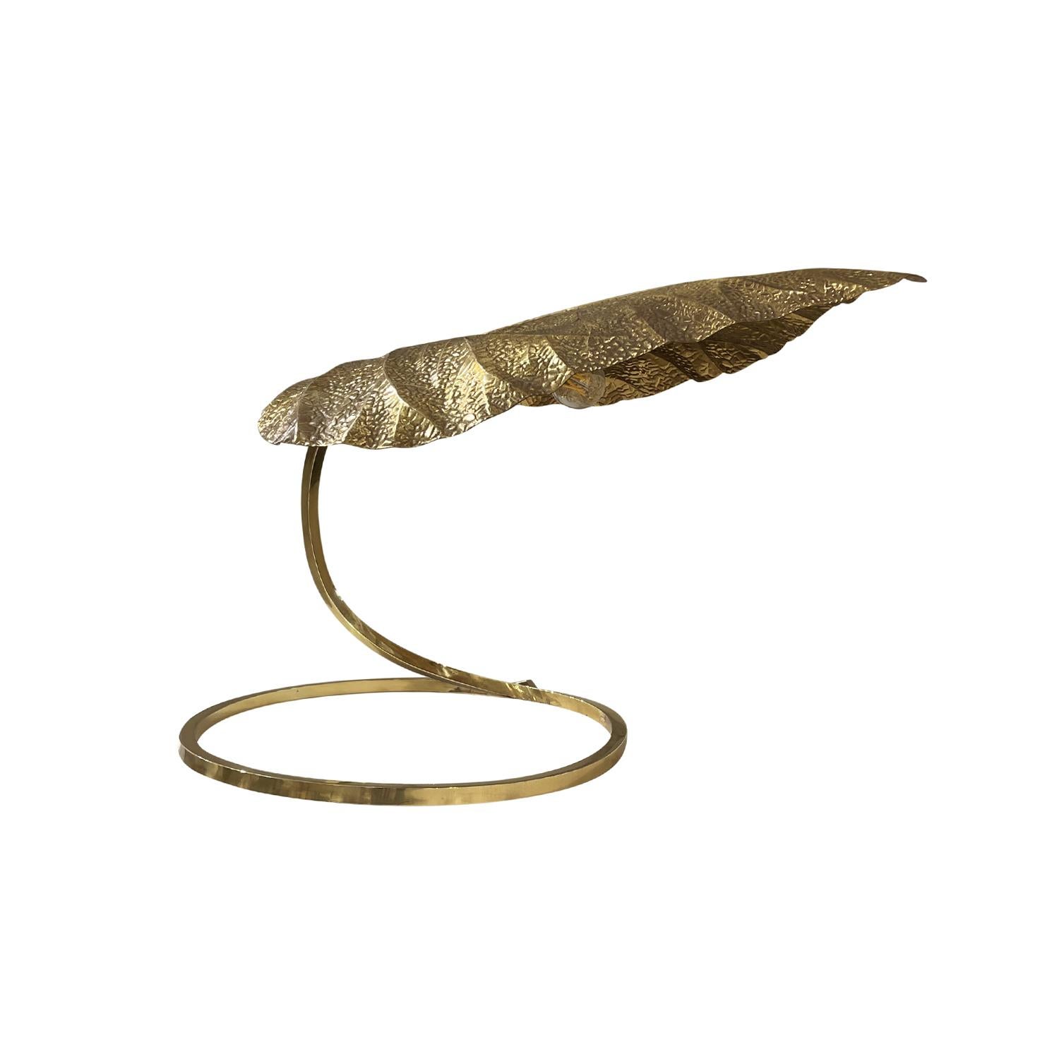 A gold, vintage Mid-Century Modern Italian Rhubarb table light made of handcrafted polished brass designed by Tommaso Barbi and Carlo Giorgi, in good condition. The sculptural lamp is composed with a large leaf which is halted by a curved arm,