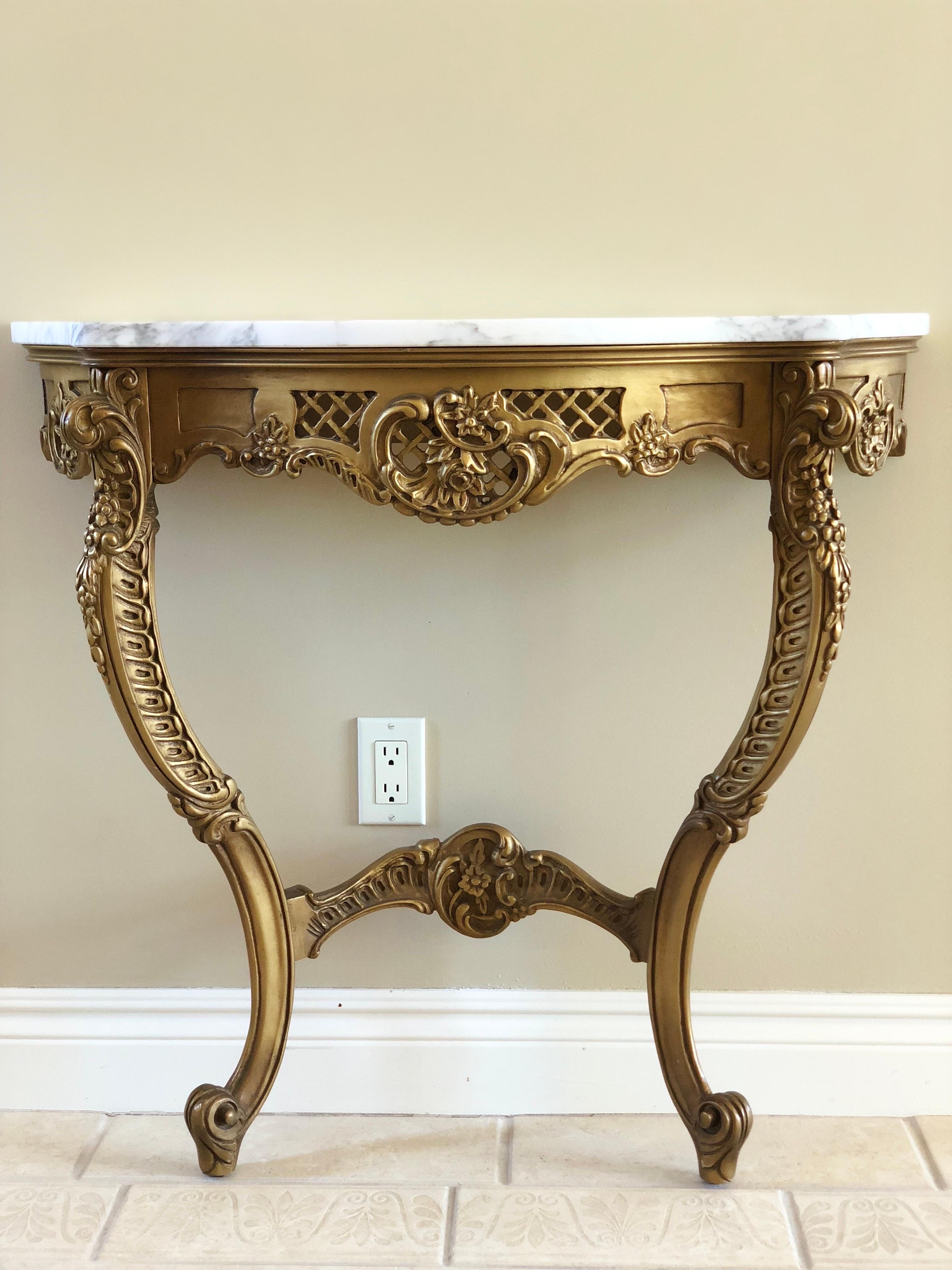 We are very pleased to offer a vintage, demilune console table, circa the early 20th Century. Classic beauty reclaims the spotlight on this beautiful piece full of fine carved details. This lovely console showcases an ornate, textured body adorned