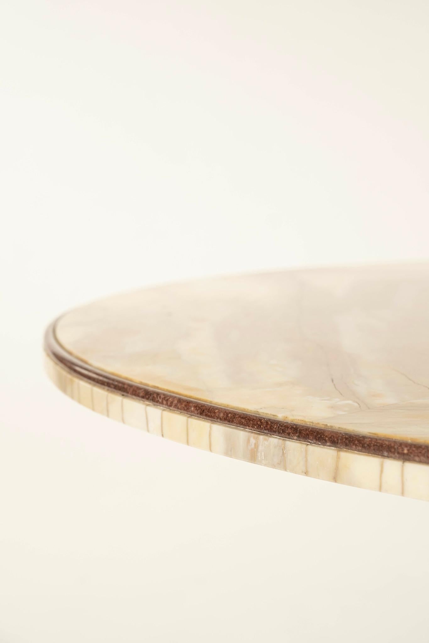 Wood, un tavolo da pranzo con piedistallo in legno intagliato del XX secolo con piano in onice dorato.
