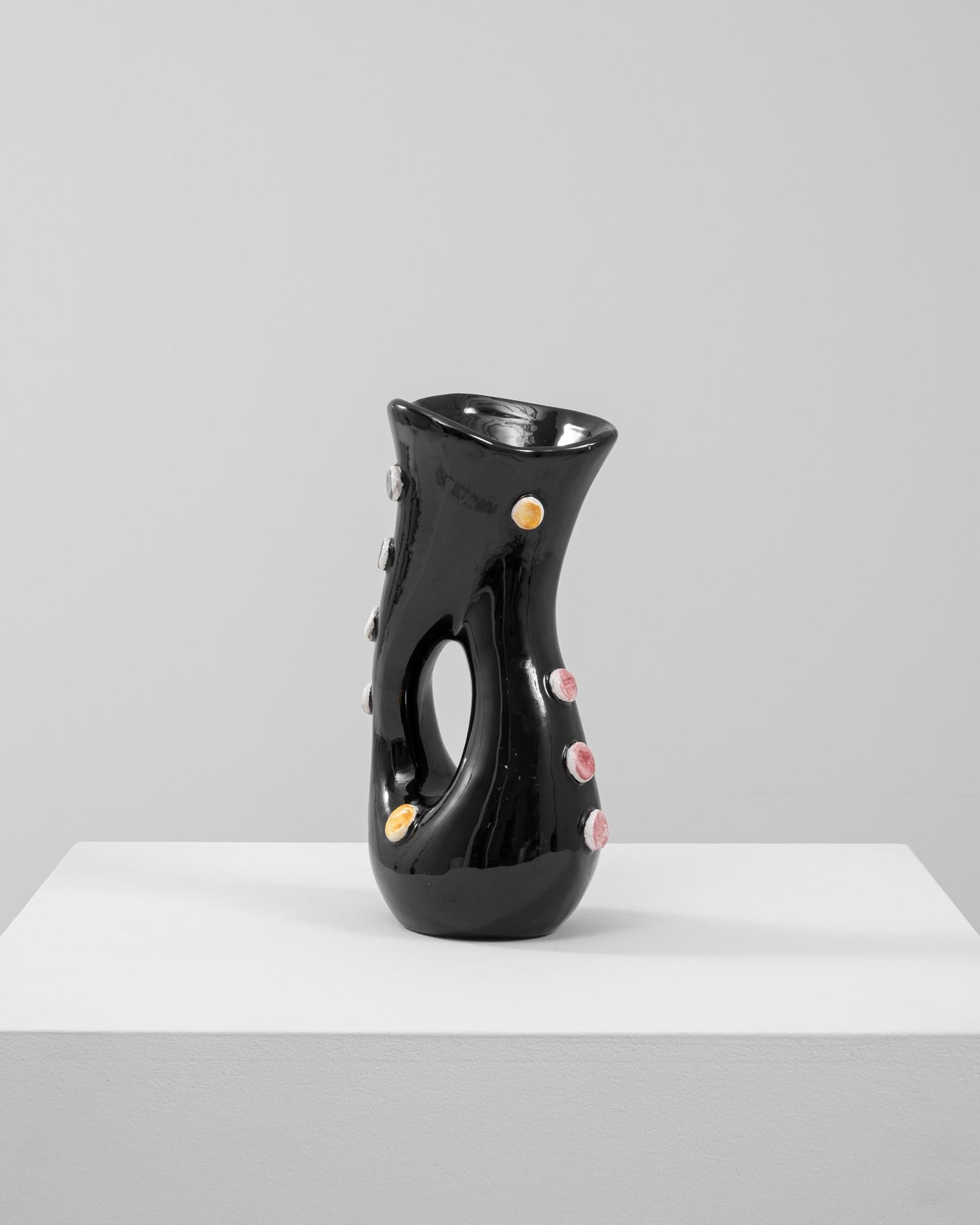 Este elegante jarrón de cerámica italiana del siglo XX es una obra maestra del diseño modernista, con un elegante esmalte negro y vibrantes detalles multicolores. La llamativa forma retorcida del jarrón con dos aberturas evoca una cualidad