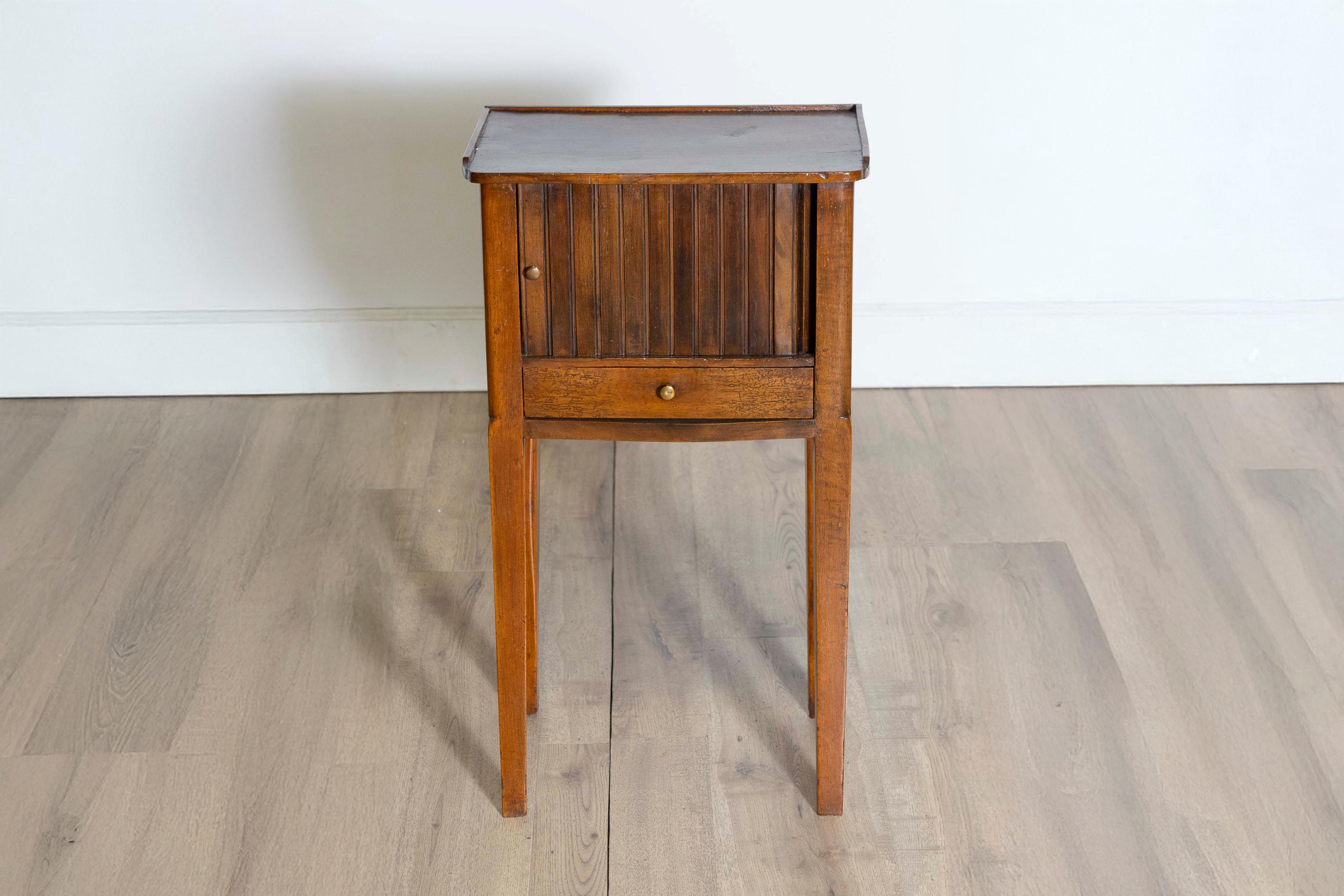 This early 20th-century Italian chevet table, circa 1900, is a charming example of functional elegance. Crafted from walnut, the table features a rich, warm tone and a smooth, polished finish that highlights the natural beauty of the wood. Its
