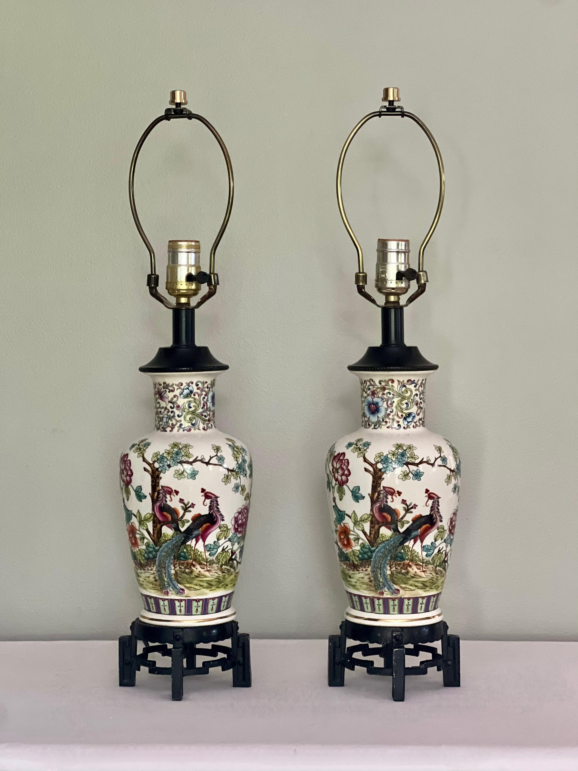 Striking circa 1950s Chinoiserie vase form table lamps with peacocks and flowers, made in Italy. Vibrant garden scene with floral decoration and a pair of peacocks beautifully painted on white porcelain with a Florentine inspired design at the neck,