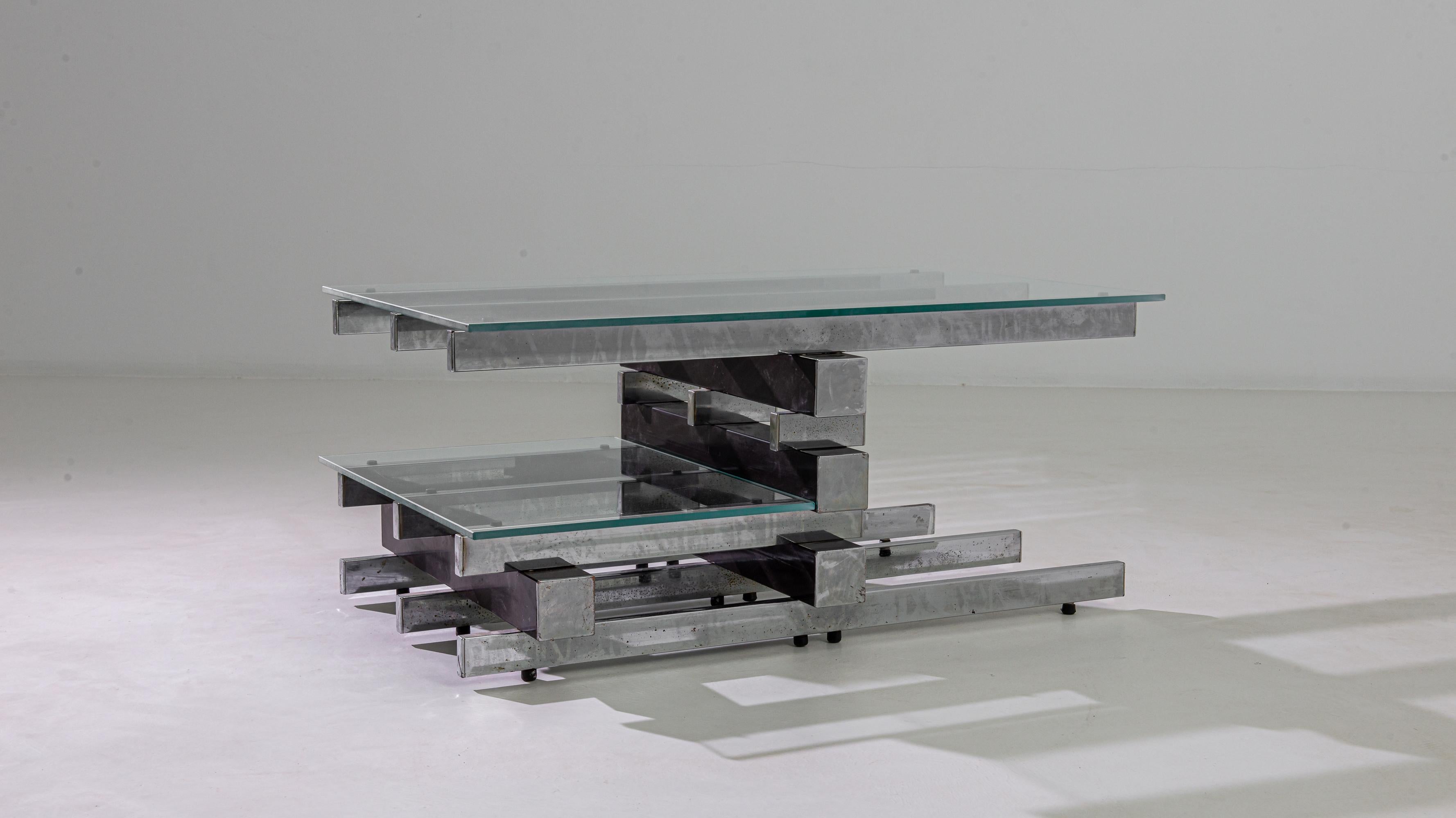 This vintage coffee table made in Italy in the 20th century boasts a unique metal base structure that is built with blocks of plated steel placed on top of each other like Jenga pieces. The lower shelf encourages aesthetic asymmetry, enhancing the