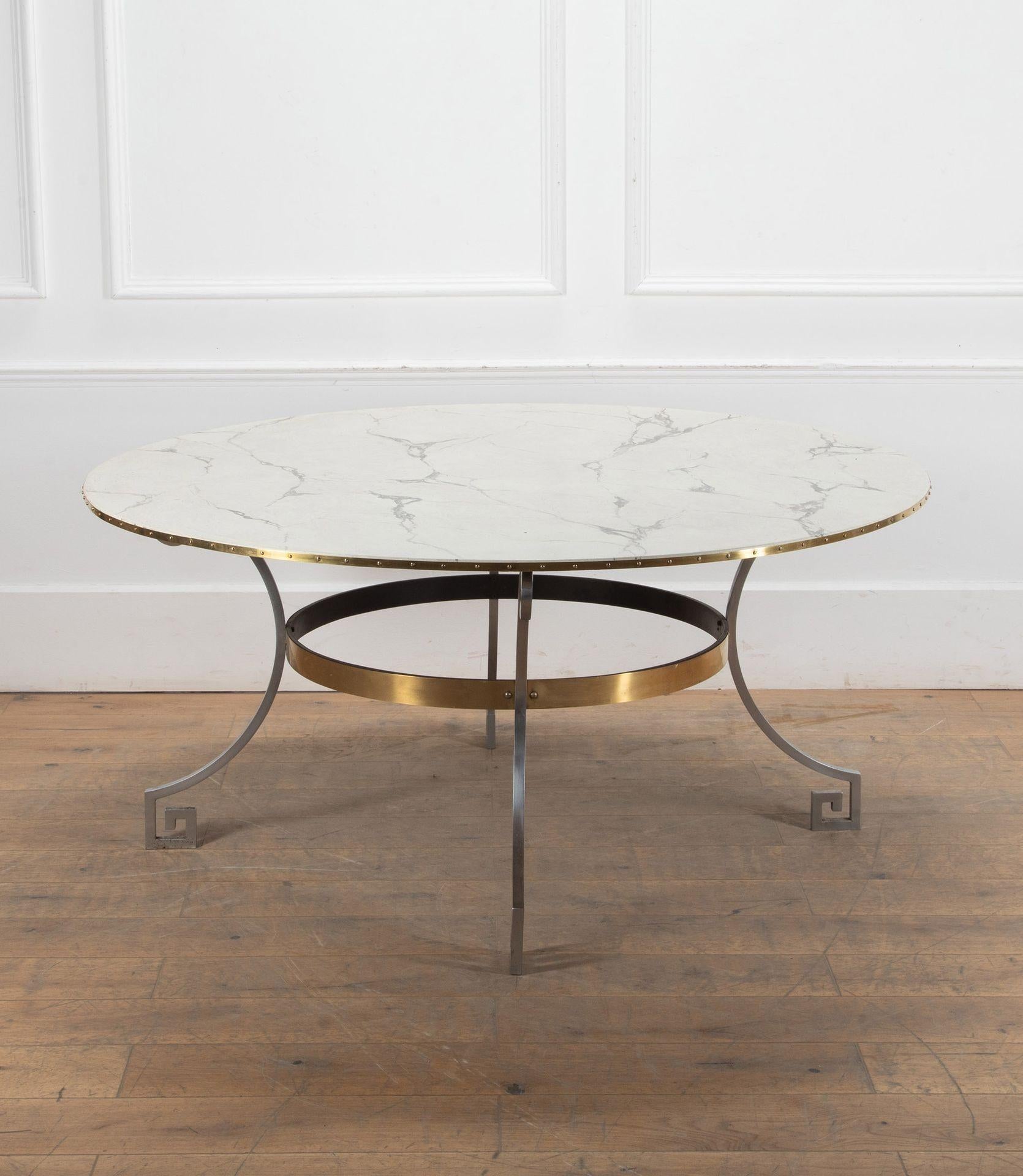 Élégante table de salle à manger circulaire italienne du milieu du 20e siècle.

Peut accueillir jusqu'à huit personnes. La base de la table est en acier massif poli et les quatre pieds sont ornés d'un motif en forme de clé grecque. 

La base est