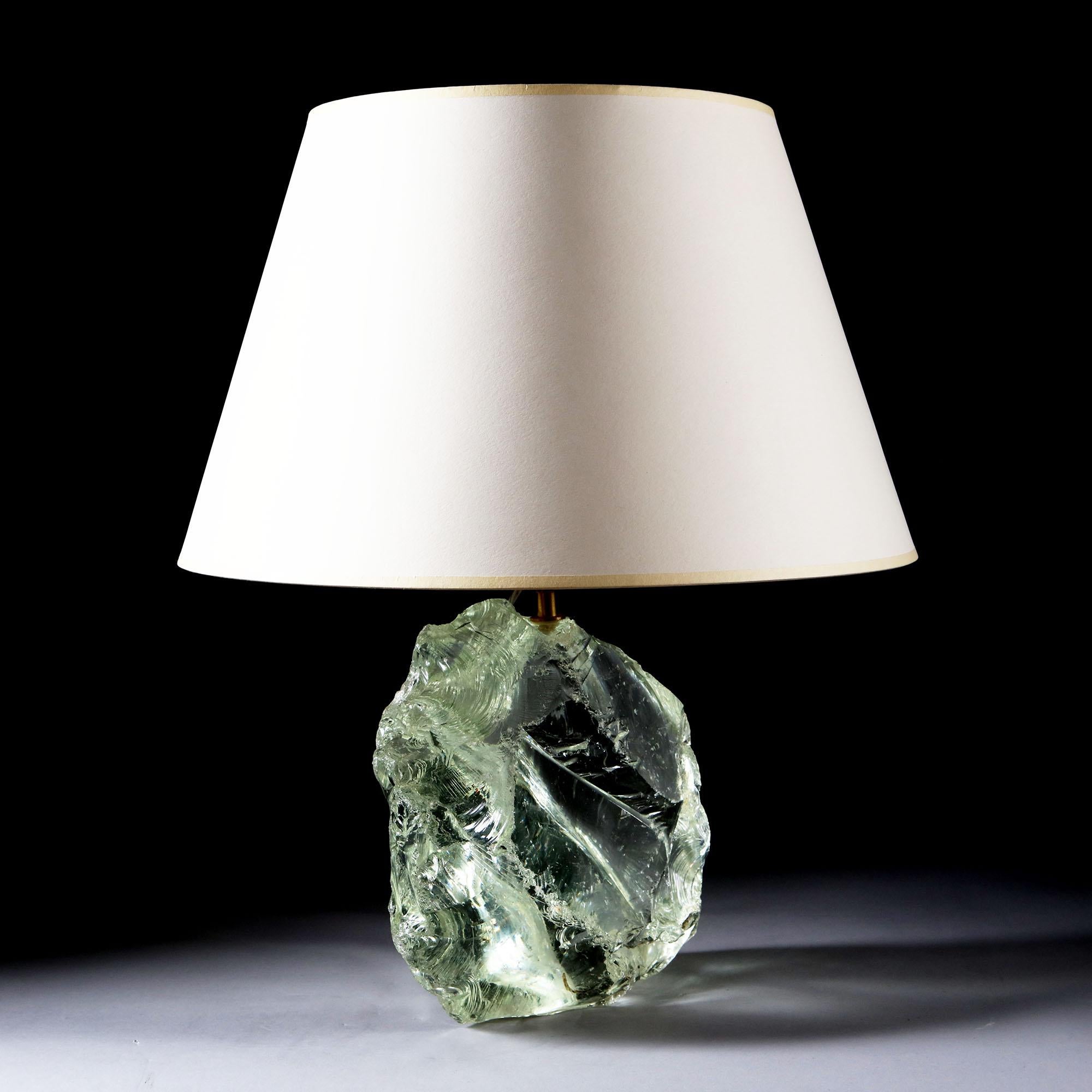 A large shard of clear glass, now mounted as a lamp.