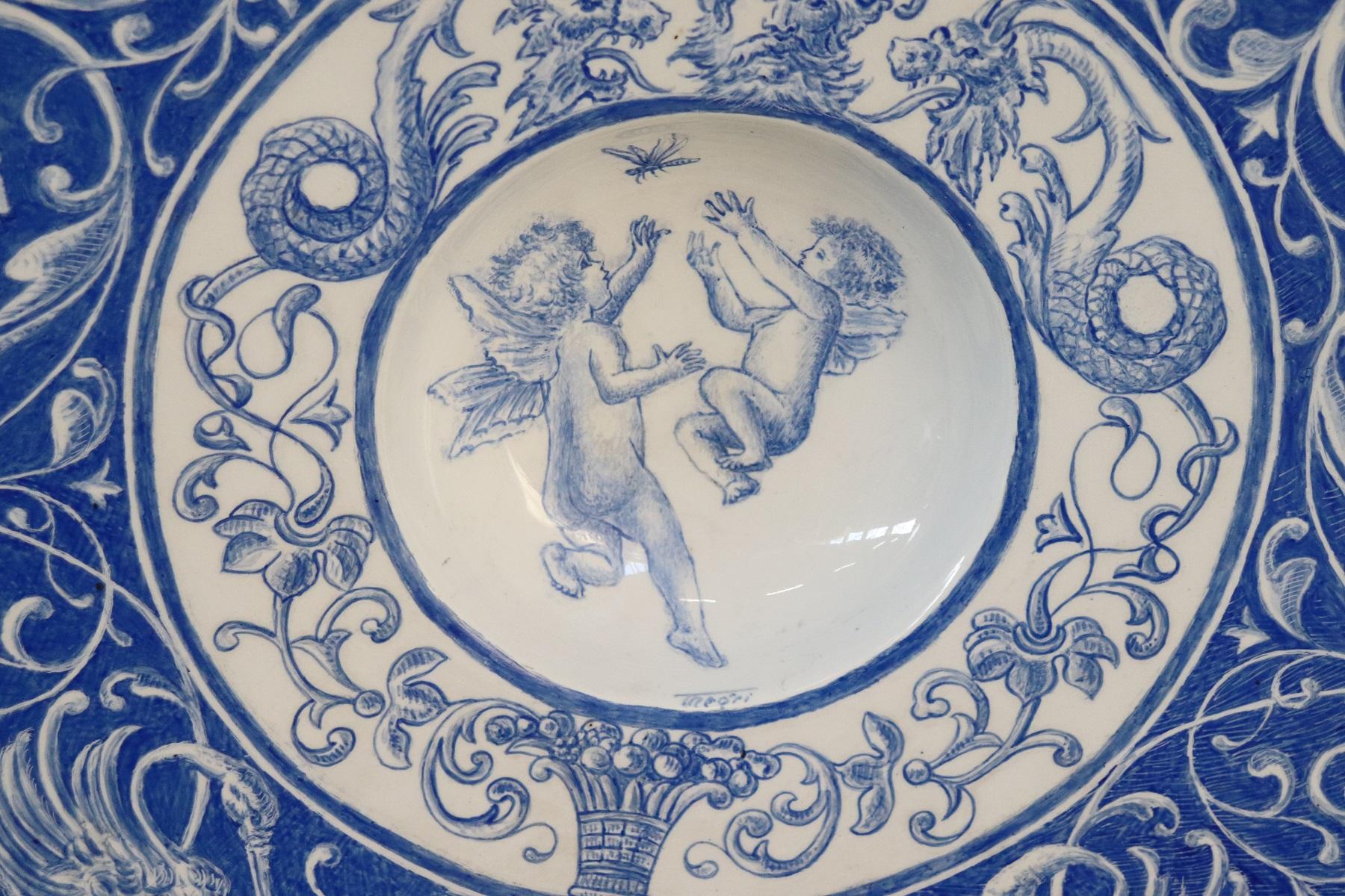 Antique Italian ceramic, 1910s. Rich decoration in shades of blue. The figures are classic in the centre two cherubs. High artistic quality. Brand at the Italian manufacturing base in Laveno. This dish is perfect as a wall decoration or at the