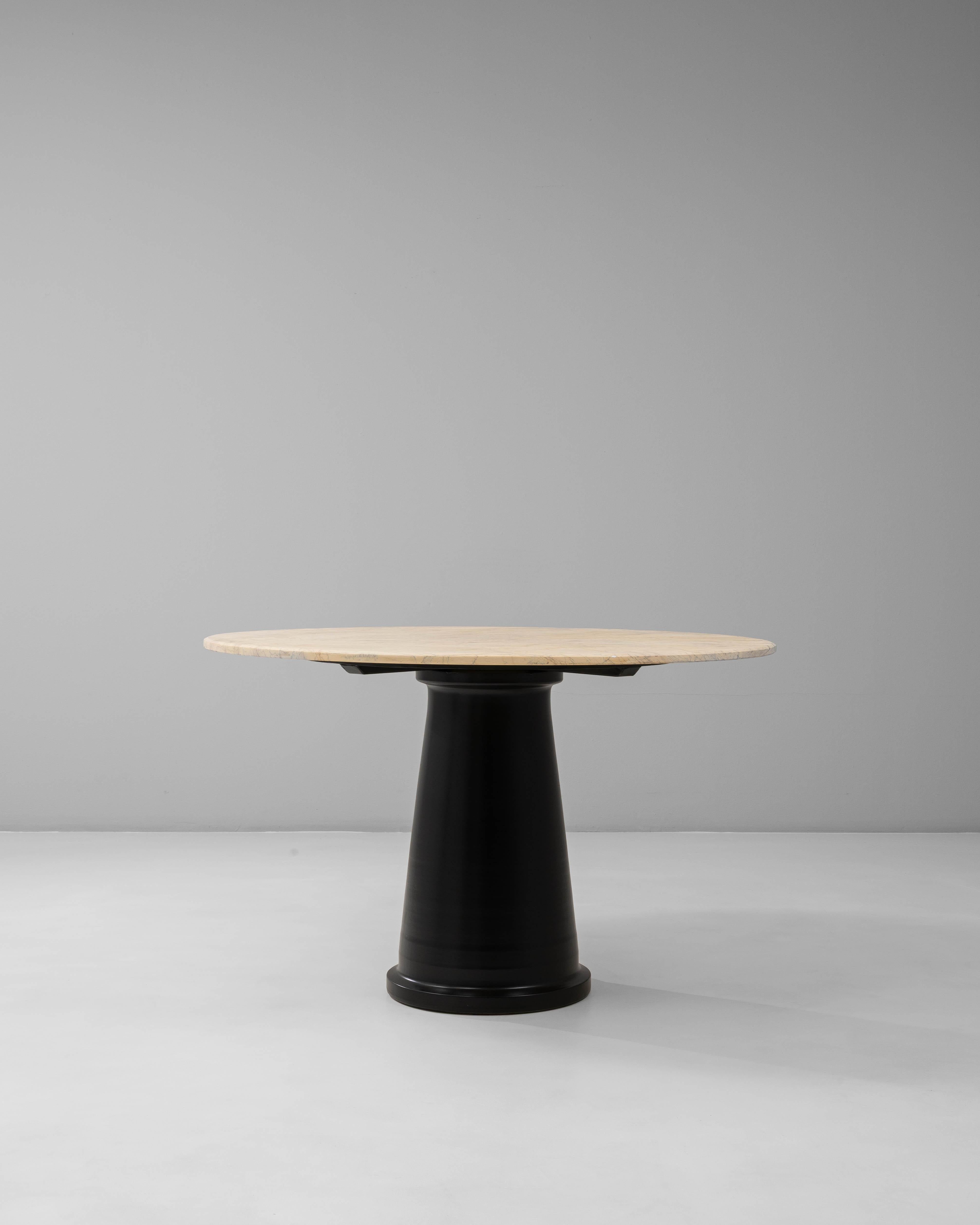 Cette table de salle à manger ronde contemporaine italienne du 20e siècle associe des matériaux raffinés à une silhouette architecturale audacieuse. Le plateau en marbre lisse présente des veines douces et un ton chaud et naturel, offrant un