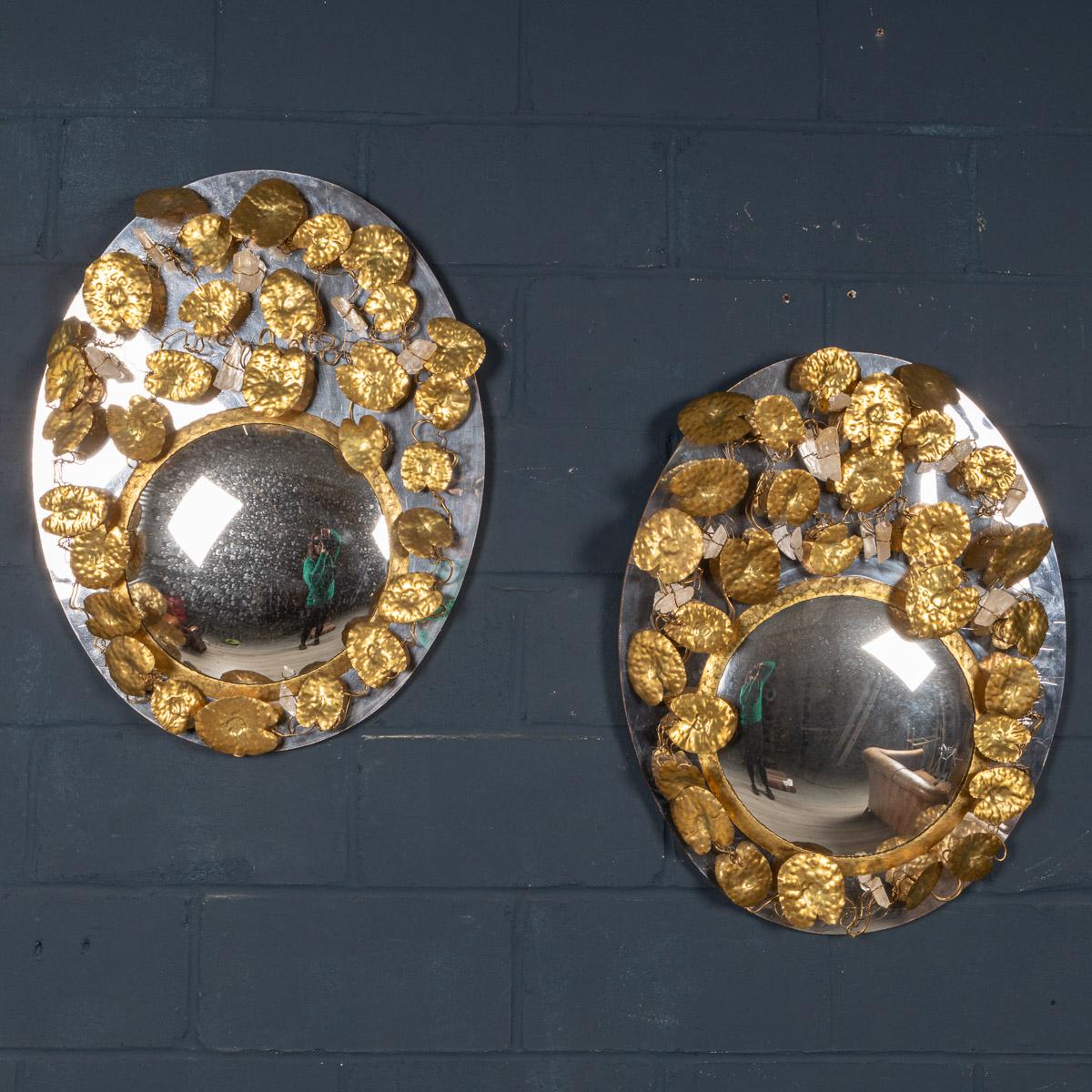 A wonderfully decorative pair of wall mirrors by Missoni, Italy, made in the latter quarter of the 20th century. The oval wood frame covered by leaves made in hammered brass, woven sections of quartz crystals and an off-centre convex