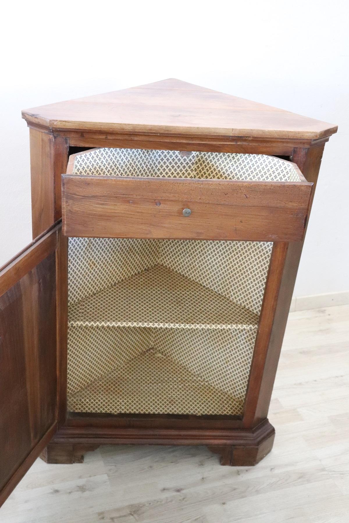 Italian corner cupboard from the first half of the 20th century. High quality furniture in walnut wood. One doors and one drawer. Very simple and perfect for any environment. Perfect to decorate a corner of your home.