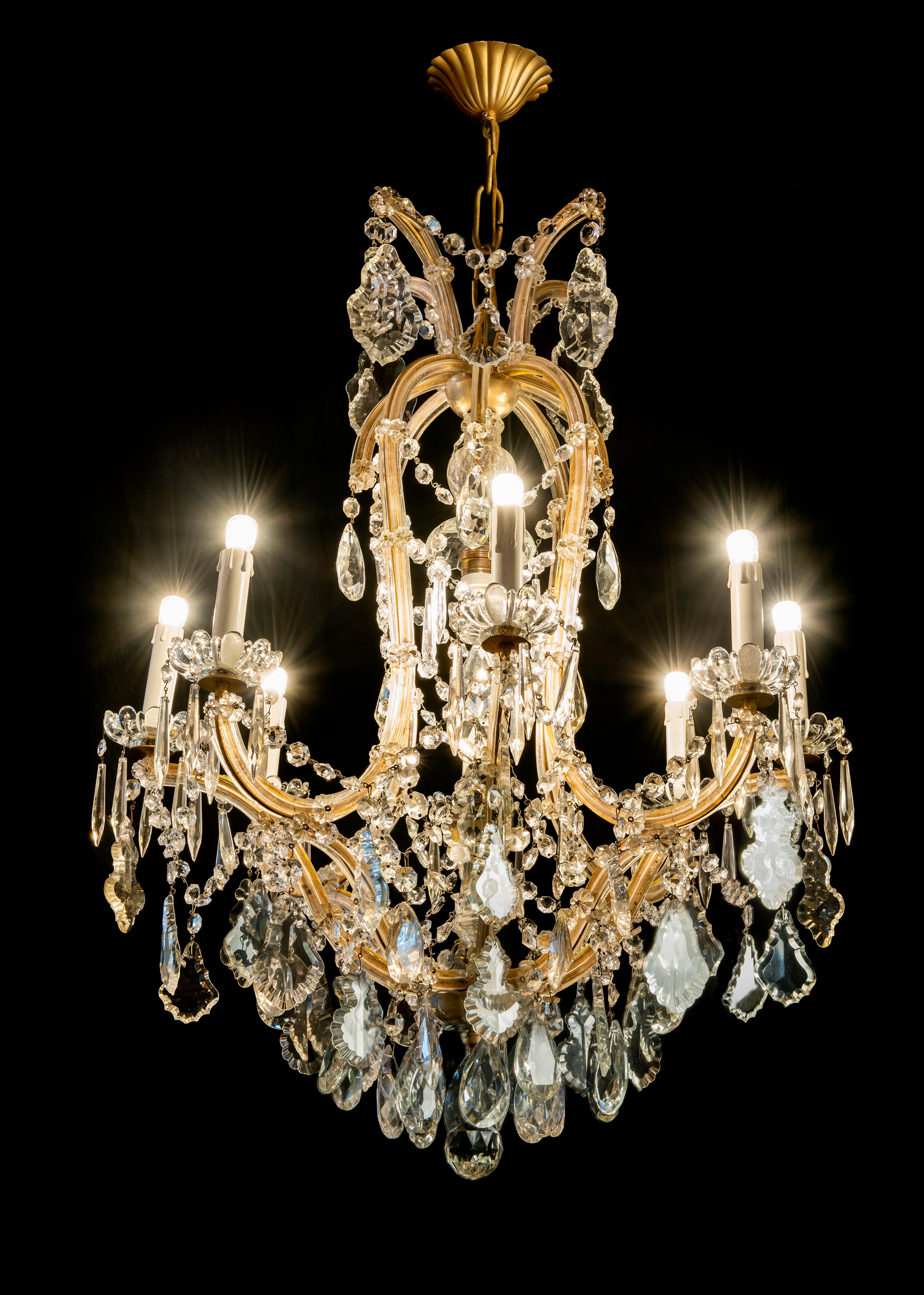 From Italy a Maria Teresa crystal chandelier fully arranged with crystal chains and drops. A nine-light chandelier with eight curved arms and one extra bulb in the upper centre of the structure. Perfect condition. New wiring for Italian