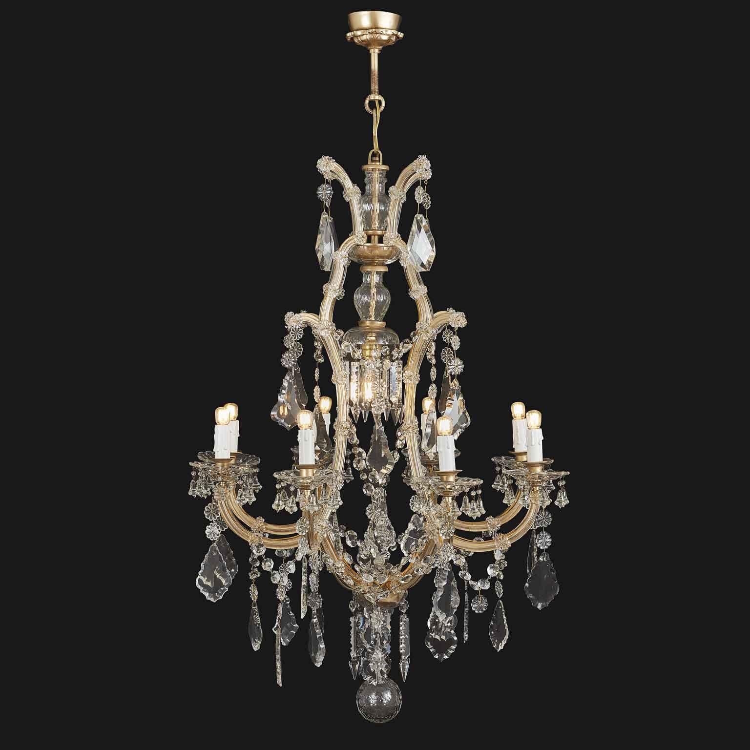 Italian Maria Theresa style nine-armed crystal chandelier dating back to 20th century. Nine arms ending with E14 light bulbs and an extra E27 bulb in the centre of the structure. This Italian vintage chandelier features a variety of faceted crystals
