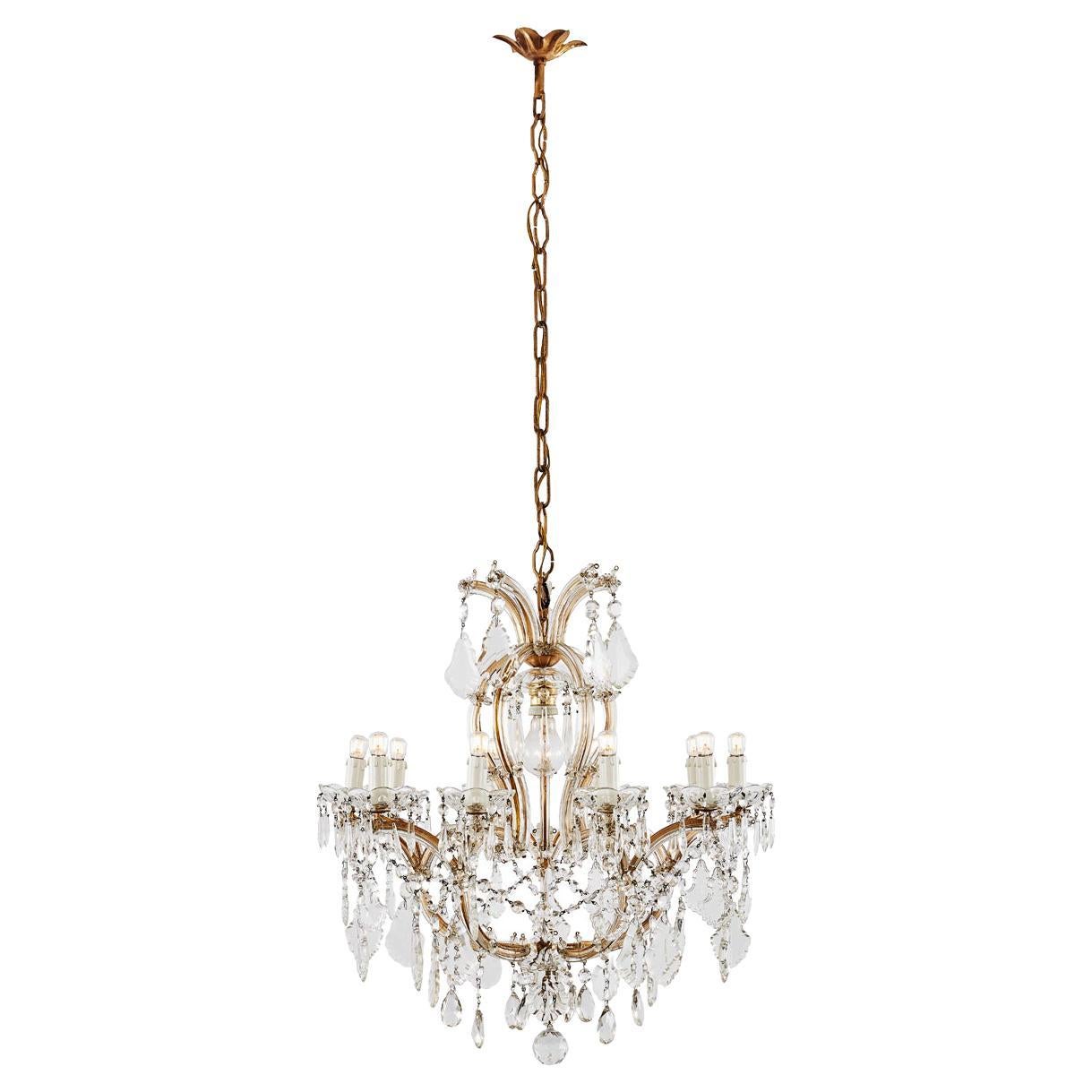 Italian Maria Theresa style ten-armed crystal chandelier dating back to 20th century. Ten arms ending with E14 light bulbs and an extra E27 bulb in the centre of the structure. This Italian vintage chandelier features a variety of faceted crystals