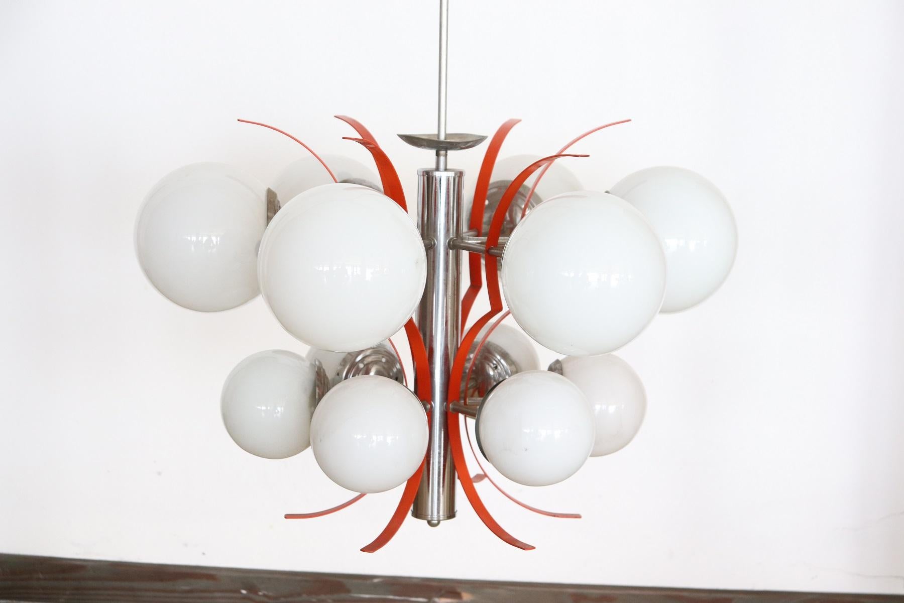 Beautiful and rare Italian design chandelier 1960s with 12 internal light. The bowls are in glass the body in chromed metal and red petals. Used good conditions.