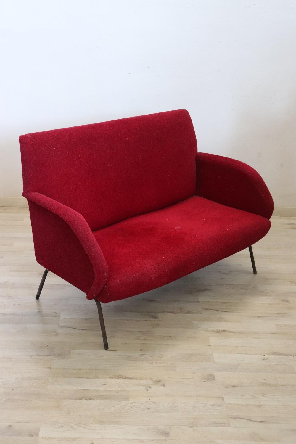 Lovely italian design sofa 1950s. Metal structure with sponge padding and red bouclé wool covering. The sofa has a perfect 1950s style line that recalls the design of Gigi Radice. The sofa has a seating capacity of two. Due to its small size it is