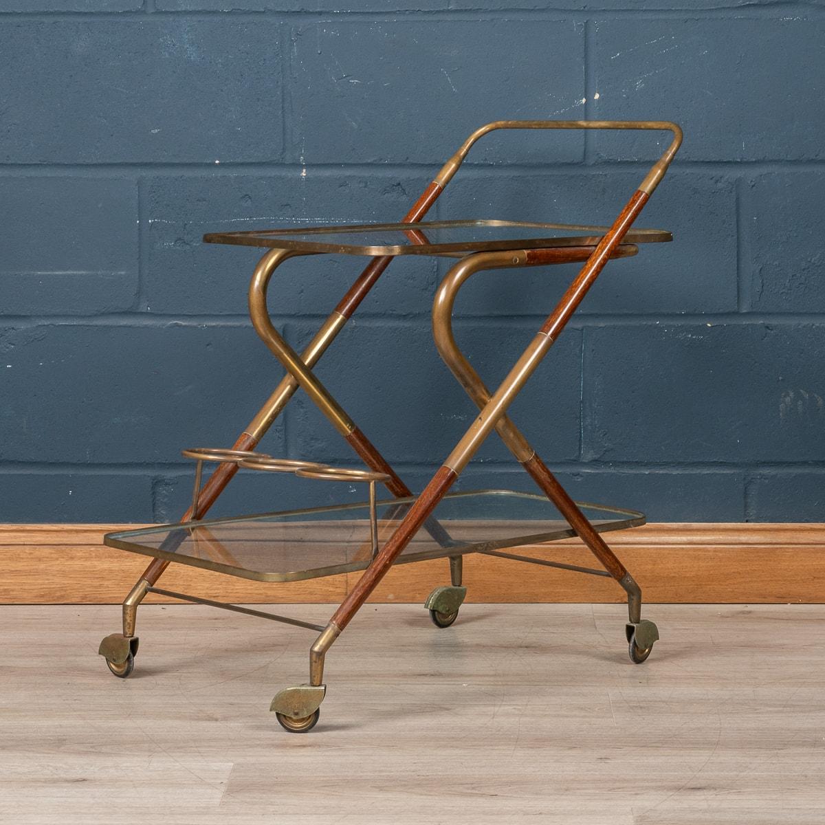 A delightful mid century Italian drinks trolley attributable to Cesare Lacca. The two tier cart is realised entirely out of teak and is a typical design of the 1950s/60s. The two glass shelves cradled perfectly by the teak frame with brass