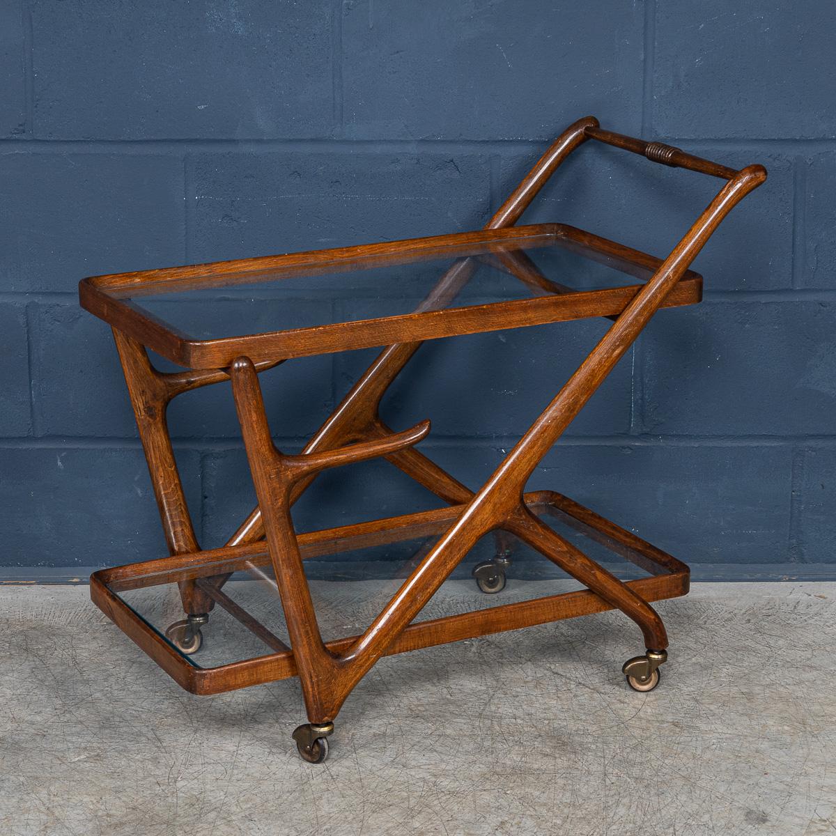 A delightful mid century Italian drinks trolley attributable to Cesare Lacca. The two tier cart is realised entirely out of teak and is a typical design of the 1950s/60s. The two glass shelves cradled perfectly by the teak frame with brass