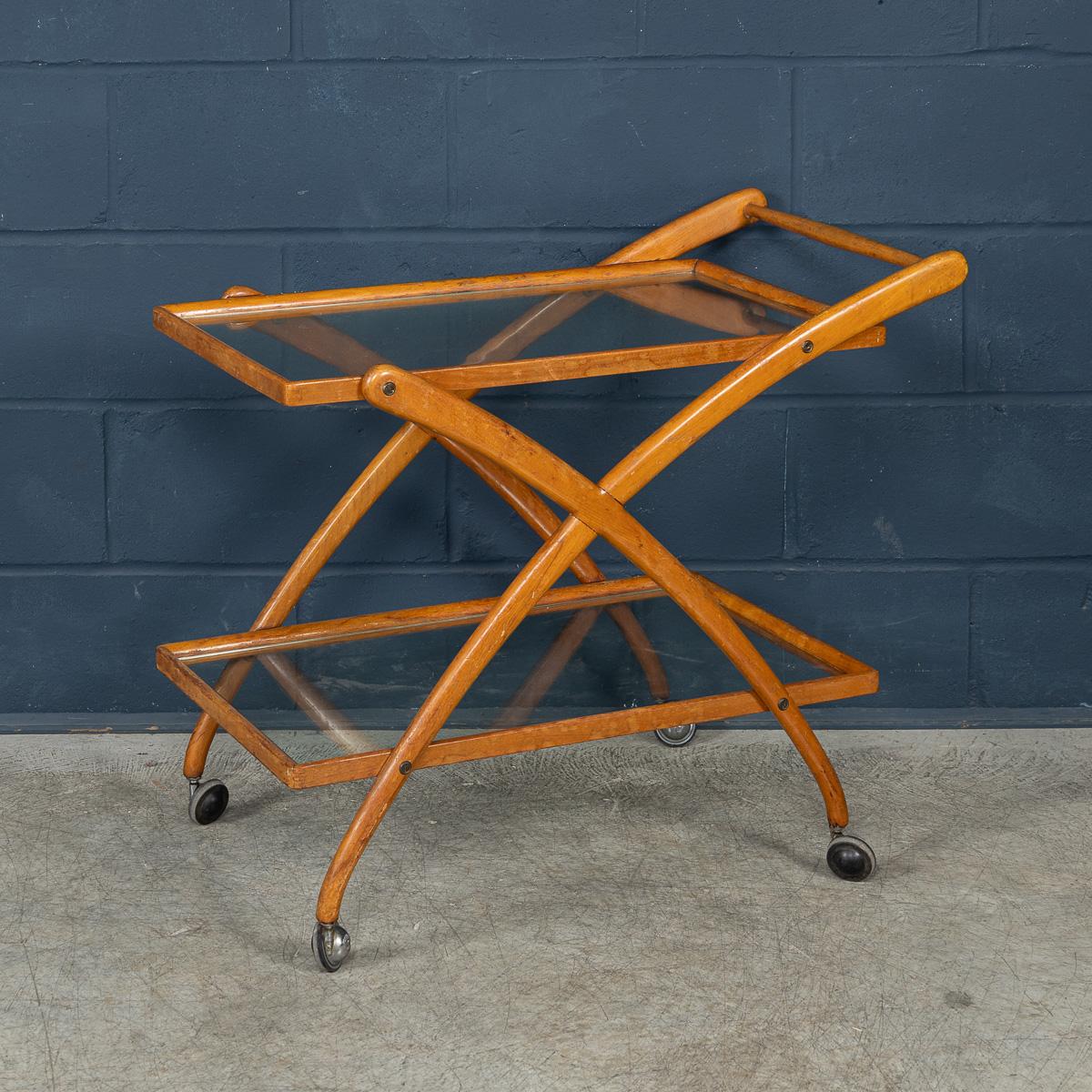 Un delizioso carrello portabevande italiano di metà secolo attribuibile a Cesare Lacca. Il carrello a due piani è realizzato interamente in teak ed è un design tipico degli anni '50/'60. I due ripiani in vetro sono cullati perfettamente dalla