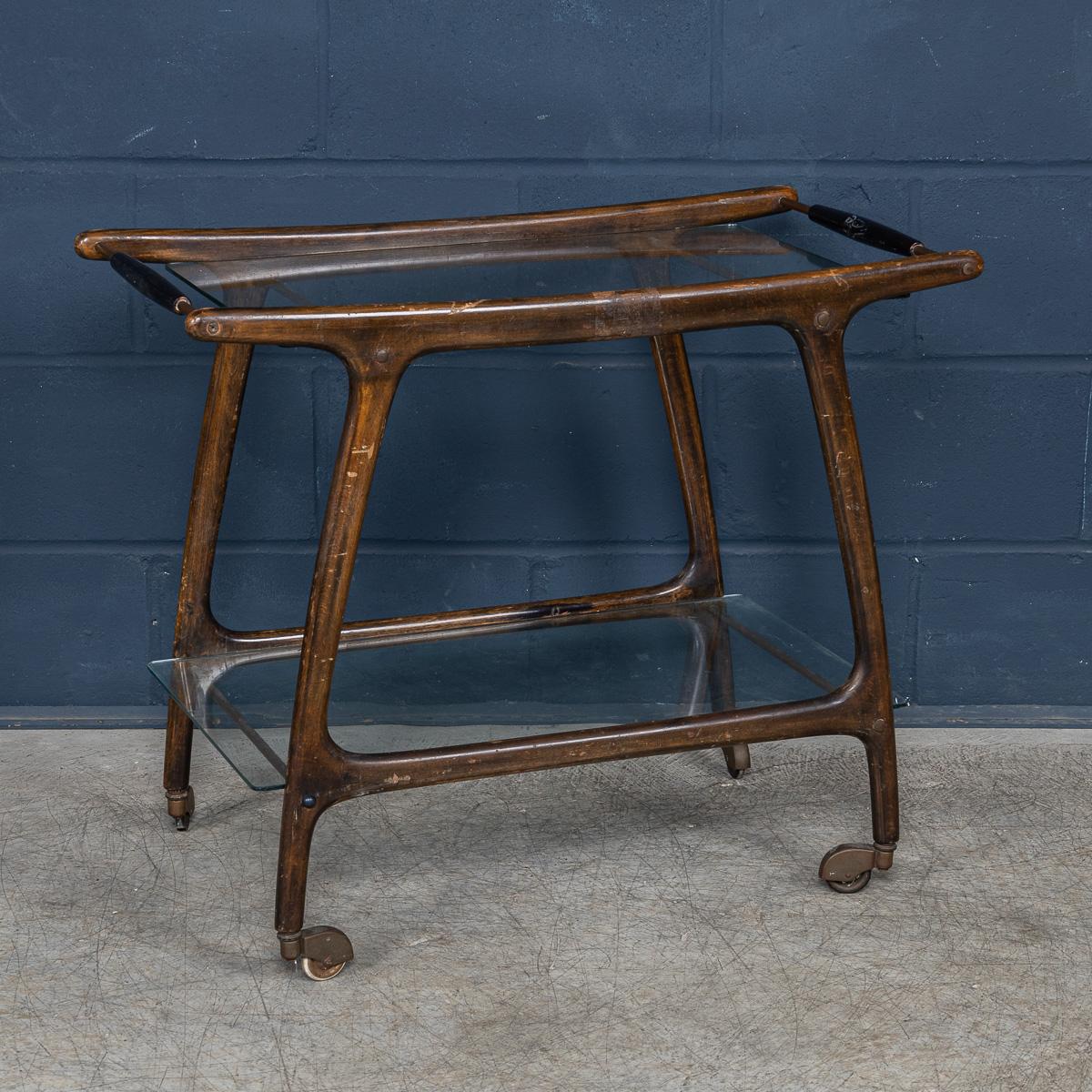 Un charmant chariot à boissons italien du milieu du siècle à la manière de Cesar. Le chariot à deux étages est entièrement réalisé en teck et présente un design typique des années 1950/60. Les deux étagères en verre sont parfaitement encadrées par