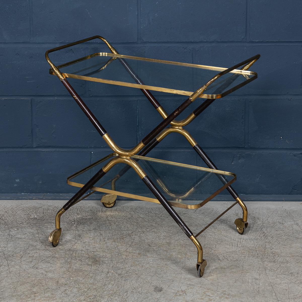 A delightful mid century Italian drinks trolley attributable to Cesare Lacca. The two tier cart is realised entirely out of teak and is a typical design of the 1950s/60s. The two glass shelves cradled perfectly by the teak frame with brass