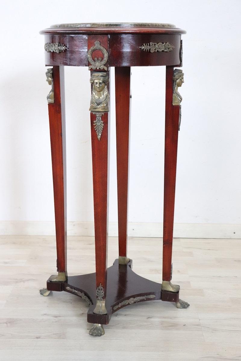 Guéridon in legno stile Impero del XX secolo con piano in bronzo e marmo. Ti presentiamo questo splendido tavolo gueridon, realizzato in Italia nella seconda metà del XX secolo. Realizzato in legno massiccio con una fantastica tonalità di rosso