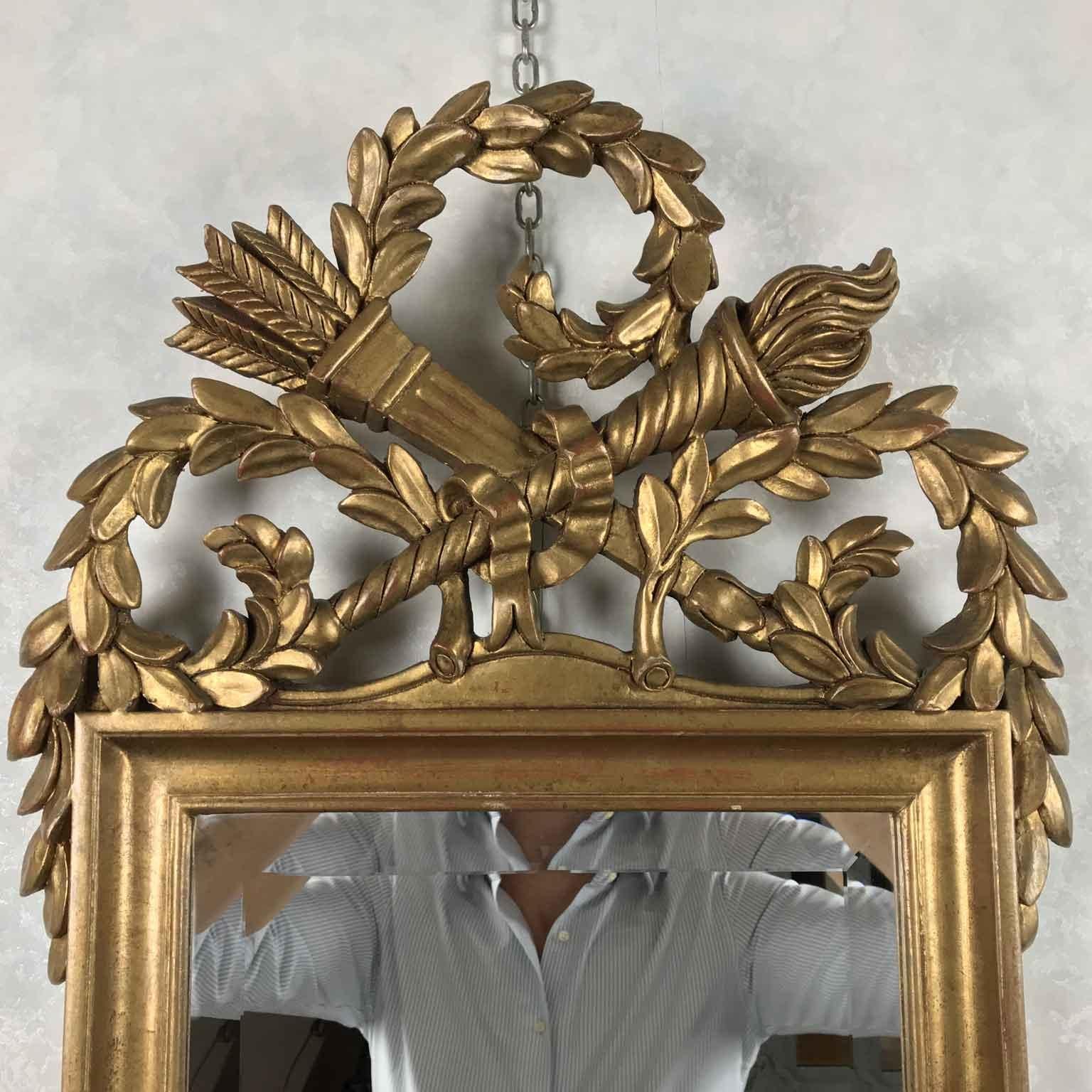 From Italy, by Chelini Firenze, a lovely late 20th century gold leaf gilded mirror with Empire style hand carved elements like quiver and torch.

Manufactured circa 1990s by Chelini Florence, it is in good age related condition, featuring a