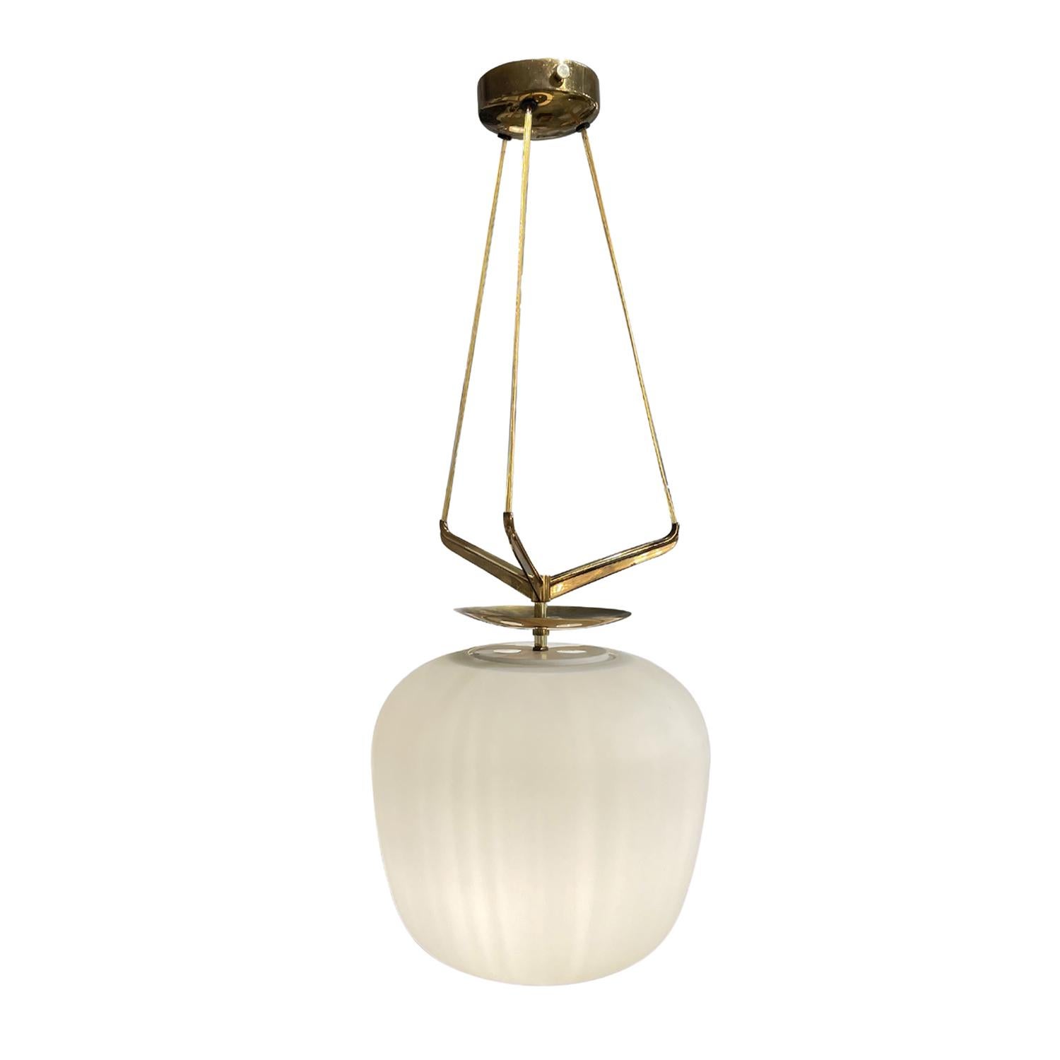 A vintage Mid-Century Modern Italian chandelier, pendant made of hand blown frosted opaline glass, designed and produced by Stilnovo in good condition. The oval white shade of the ceiling light, lamp is supported by a sculptural polished brass