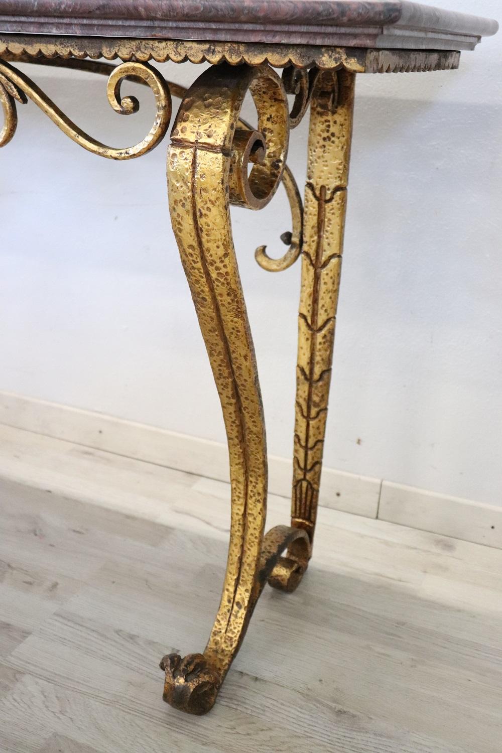 Beautiful console table, 1980s. Made of fully gilded wrought iron. Characterized by an elegant wavy line. The top is in precious red marble. You can receive perfectly conditions your console table place them immediately in your home and use them.