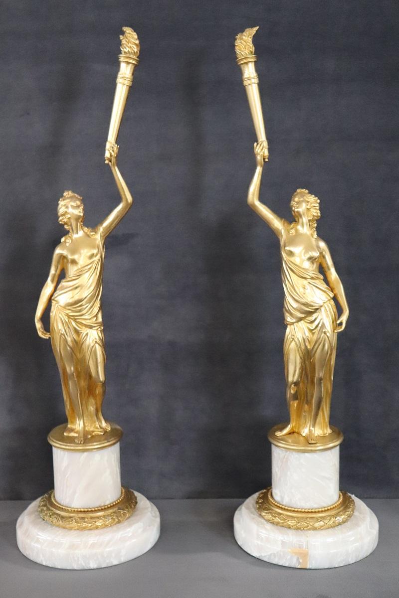 Paire de sculptures en bronze doré du 20e siècle sur une base circulaire en albâtre. Deux figures féminines de goût classique, allégories de la liberté. D'un grand raffinement et d'une grande qualité artistique.