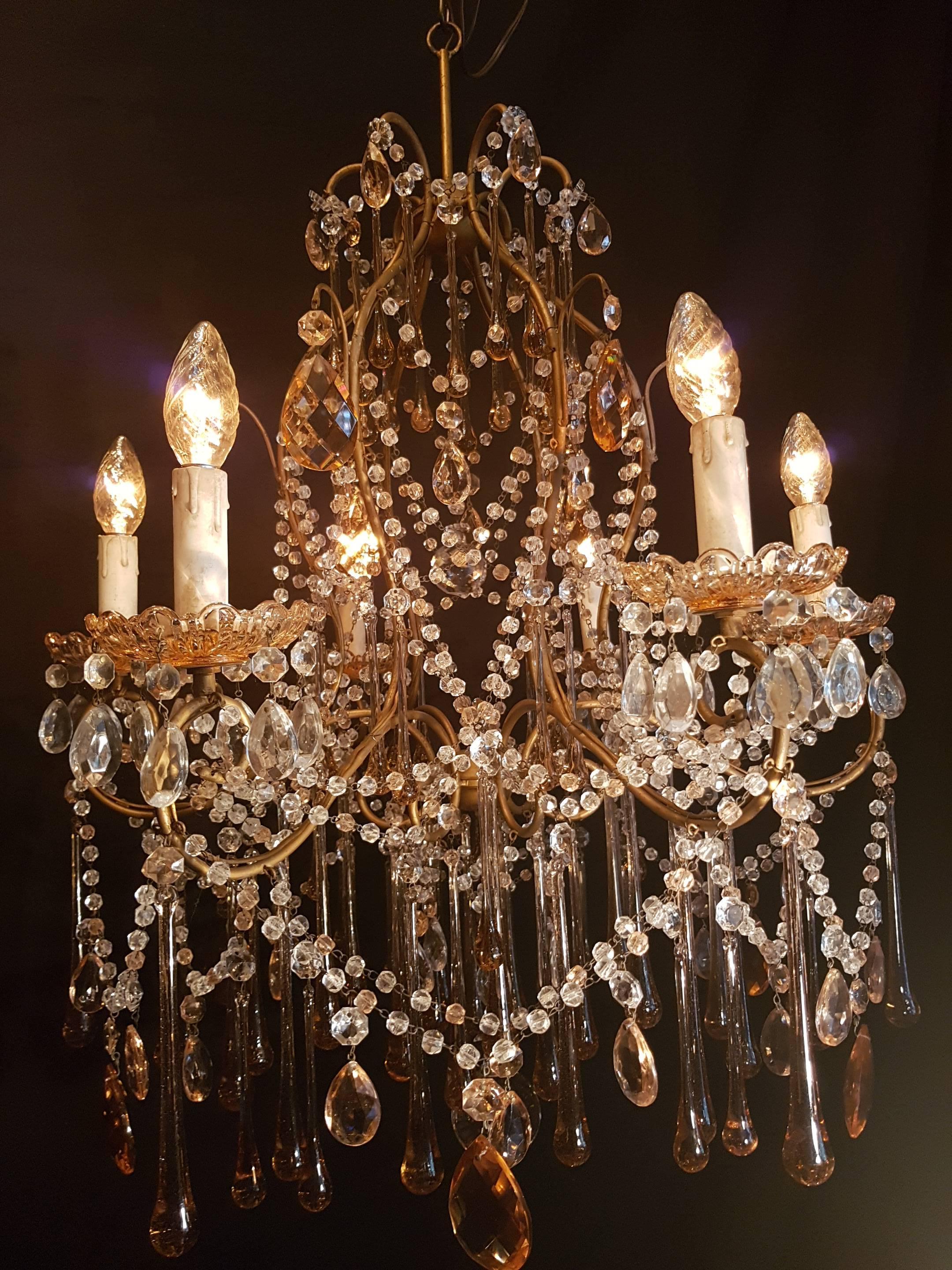 20th century six-light Italian gilt-metal chandelier with crystals and big glass drops in salmon color. Also the bobeches are in the same color and so are some of the beads in the strings. Very rare and richly decorated piece.