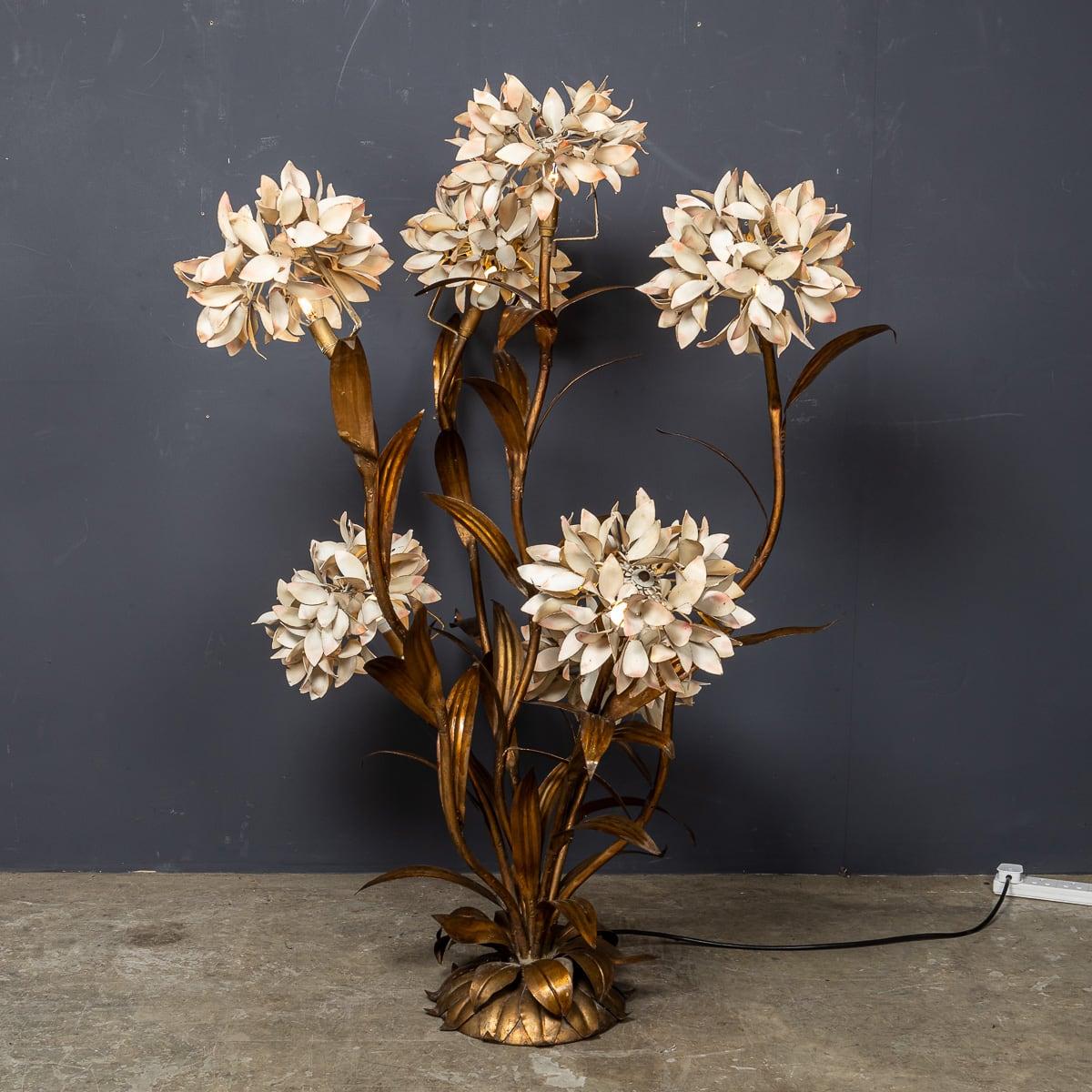 Superbe lampadaire italien du XXe siècle en métal doré et émail, conçu dans un motif végétal avec sept fleurs émaillées blanches, chacune abritant une ampoule. Lorsqu'elle est allumée, elle projette une lumière douce et ambiante qui s'accorde aussi