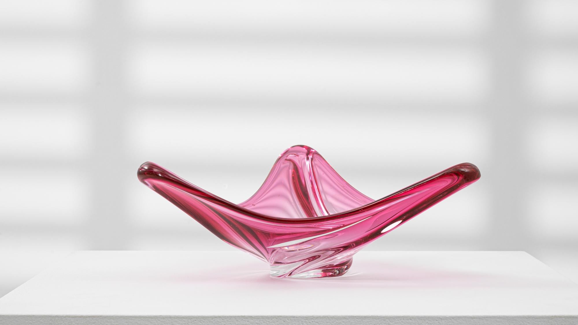 This 20th Century Italian glass plateau exemplifies the organic elegance and fluid artistry associated with Murano-style glassmaking. Crafted in a vivid pink hue with a clear base, the piece features dramatically flared edges and a sculptural,