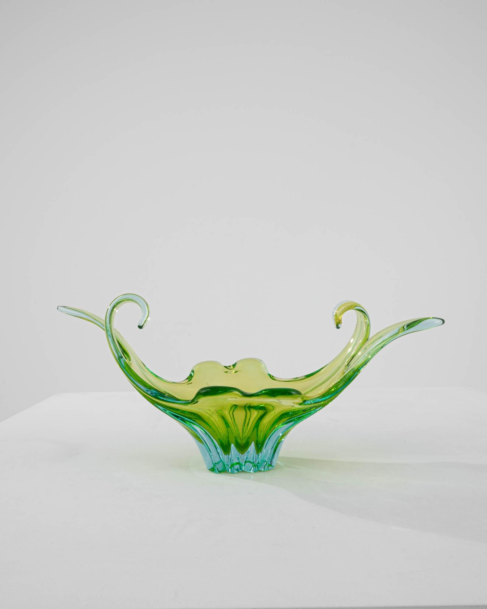 Combining a graceful silhouette with a vibrant, eye-catching interplay of colors, this vintage glass plateau offers a unique objet d’art. Made in Italy in the 20th century, the impressive craftsmanship necessary to form such a complex piece is