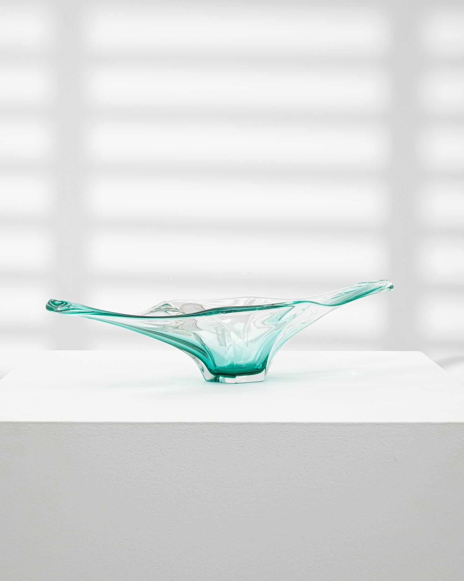 This 20th Century Italian glass plateau is a refined example of Murano-inspired craftsmanship, notable for its elongated form and clear aqua tone. With its gracefully stretched arms and undulating rim, the piece evokes a sense of balance and