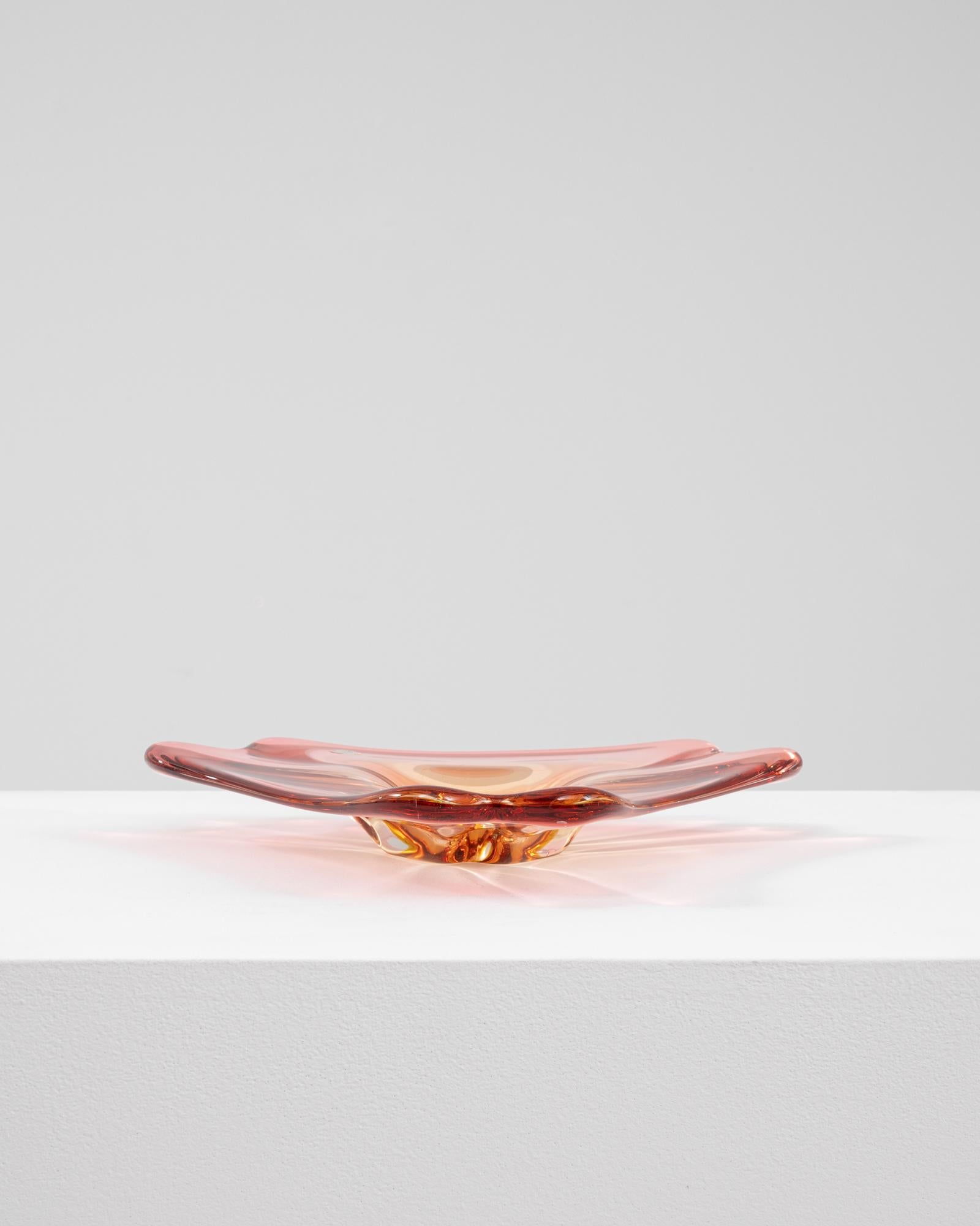 This 20th Century Italian glass plateau features a sleek, low-profile design with gently flared edges, rendered in a rich amber hue. Its handblown construction displays the hallmark fluidity and clarity of Murano glass, with subtle rippling at the