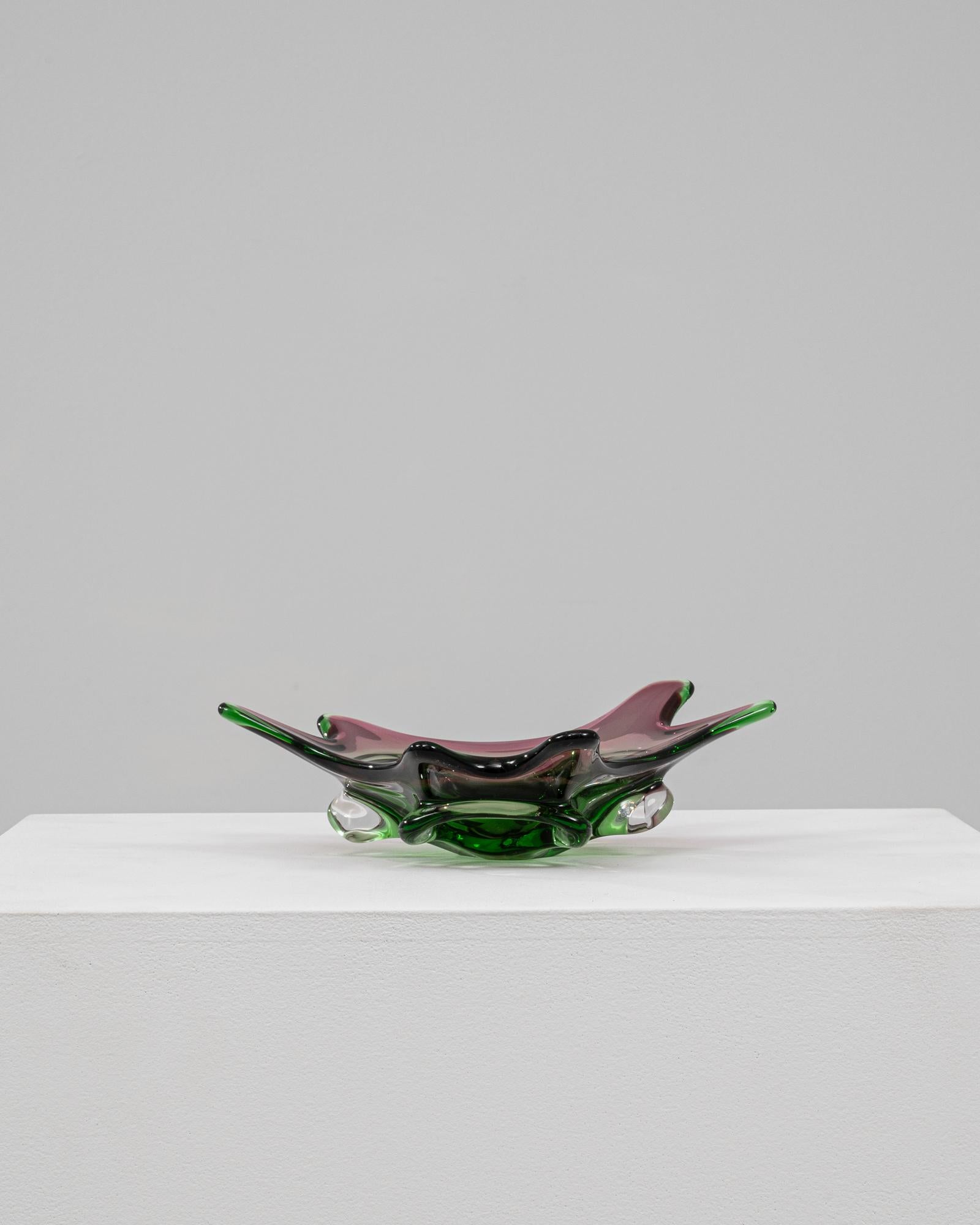 This 20th Century Italian glass plateau is a vibrant expression of mid-century Murano artistry, characterized by its sculptural form and rich color palette. The bowl features dramatic, undulating edges and pronounced pulled points that create a