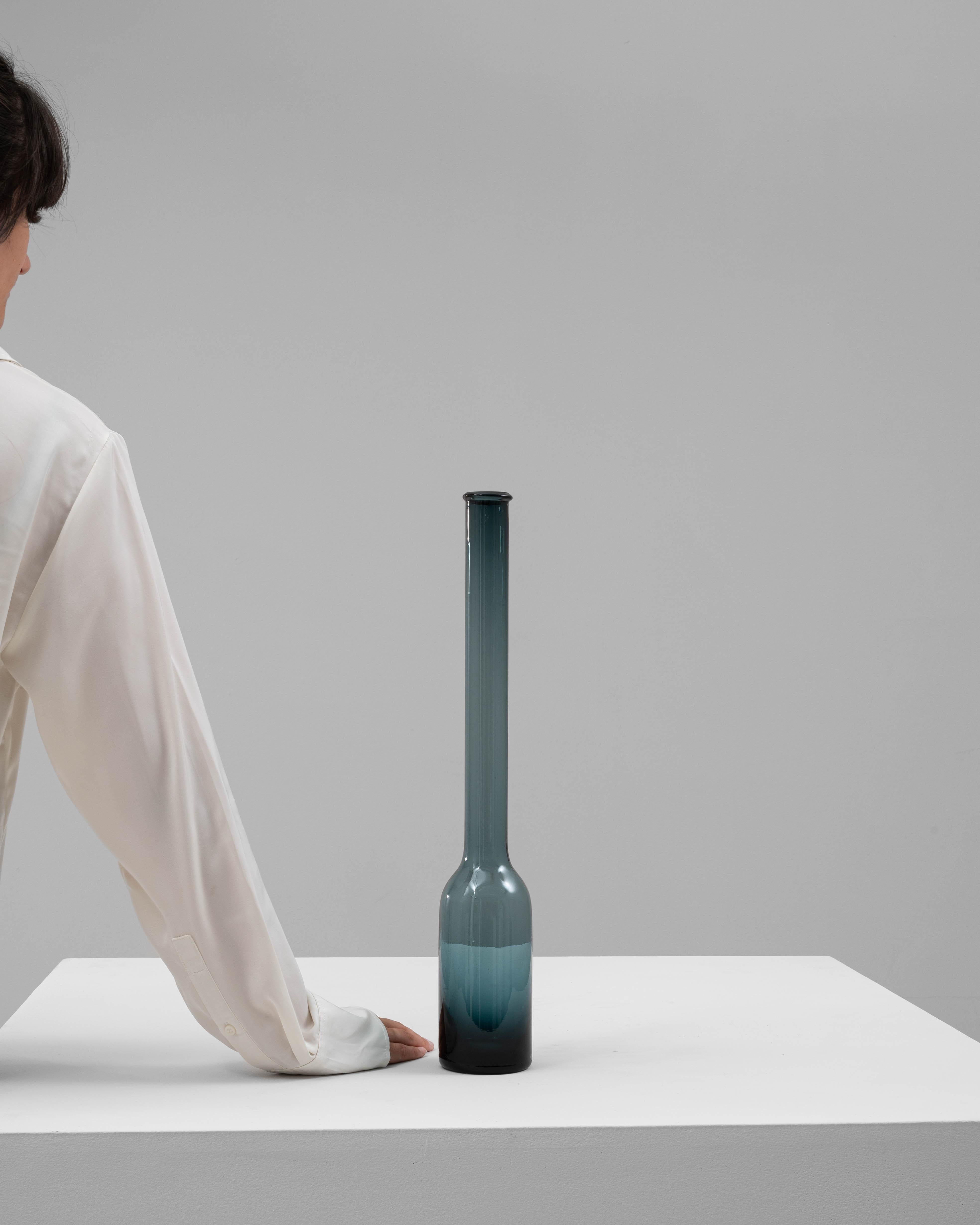 Ce vase en verre italien du XXe siècle est un exemple frappant d'élégance minimaliste. Fabriquée en verre soufflé à la main, elle présente un col mince et allongé qui se transforme gracieusement en une base arrondie. Le dégradé de tons sarcelle