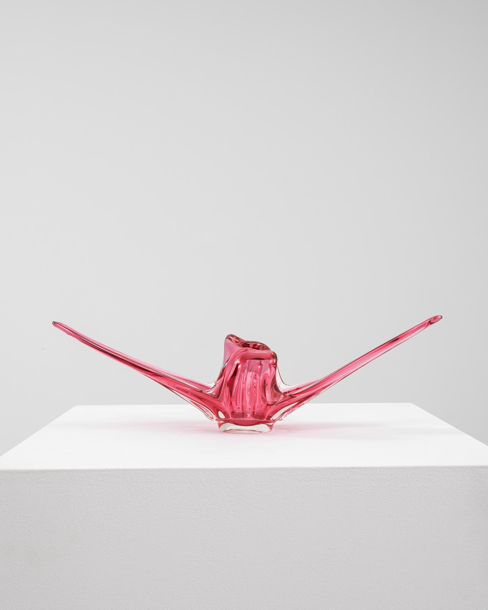 This 20th Century Italian glass vase is a bold and expressive example of Murano-style design, featuring a radiant pink hue with a clear glass base. The handblown form flares dramatically into elongated, wing-like extensions that rise and twist