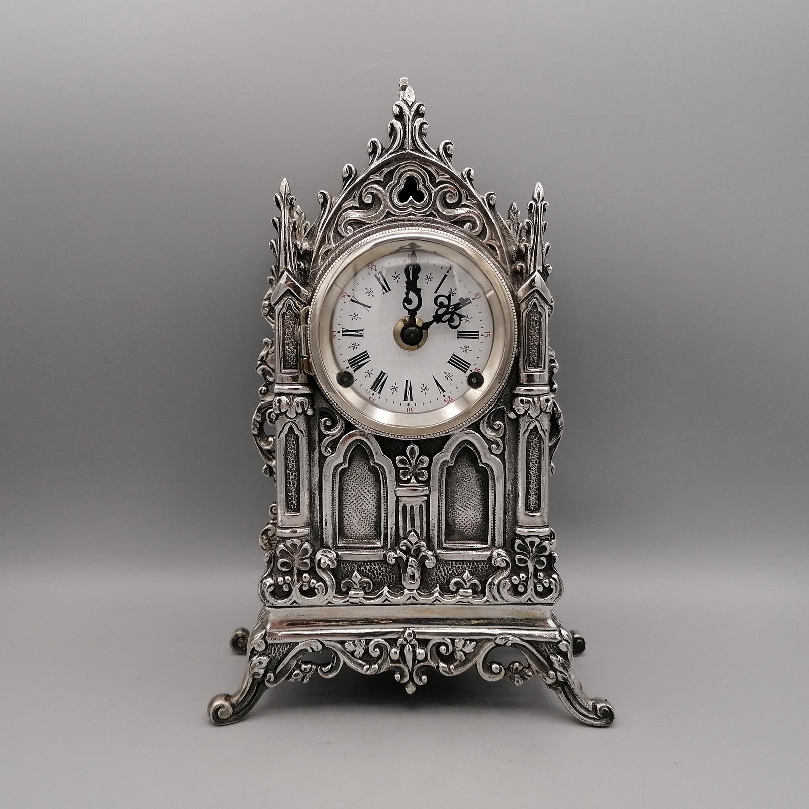 Solid silver 800 table clock made in Italy in Milan at the end of the 20th century. The clock was made in neo-Gothic style with the casting technique and finished with chisel in all its parts.
The movement is mechanical with a spring load and is in