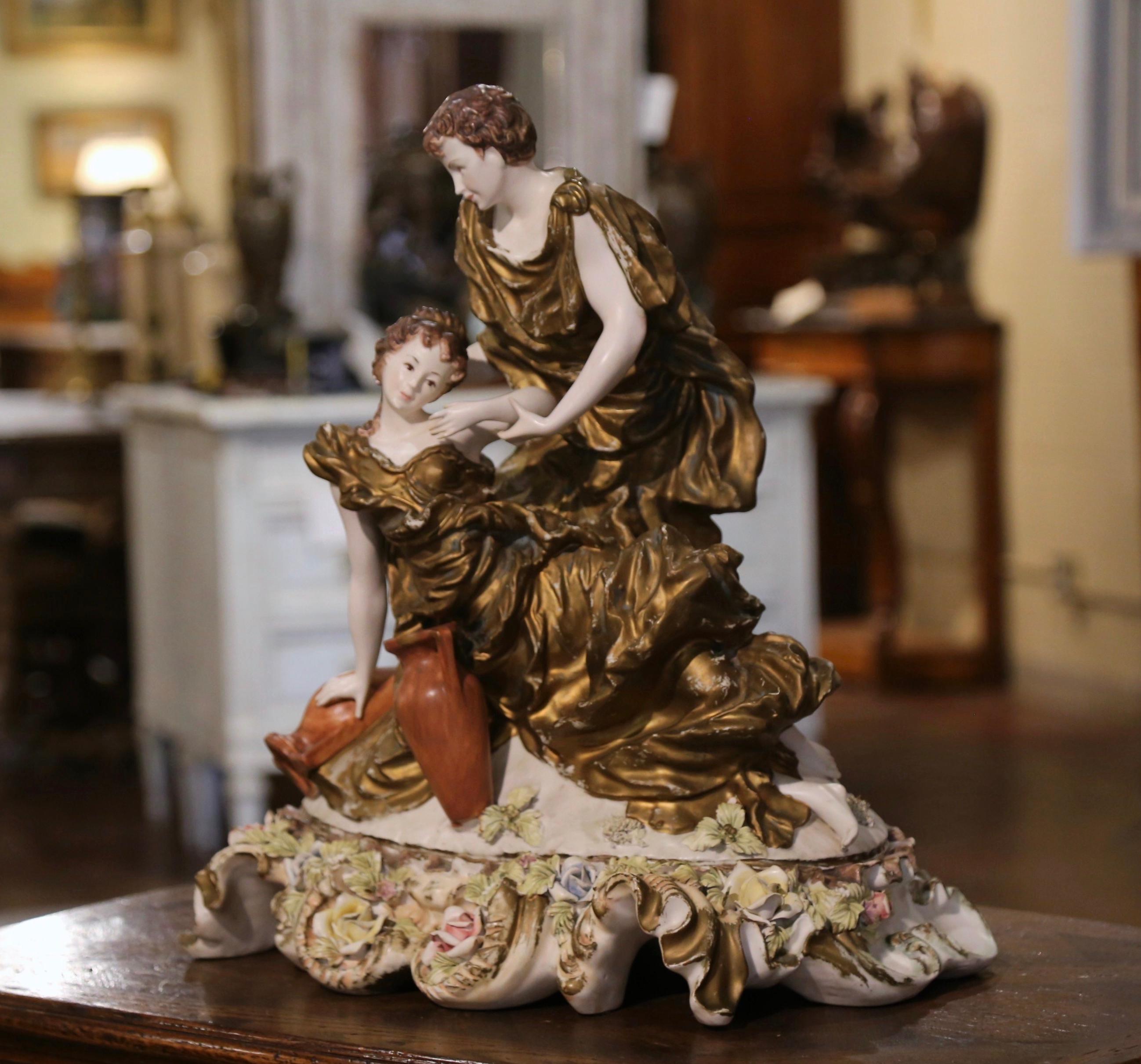 This beautiful majolica figurine would elevate any living room, kitchen, or entry way. Created in Italy circa 1950 and done in the Capodimonte style, the barbotine statue portrays a youthful couple adorned in classical Roman attire. Draped in