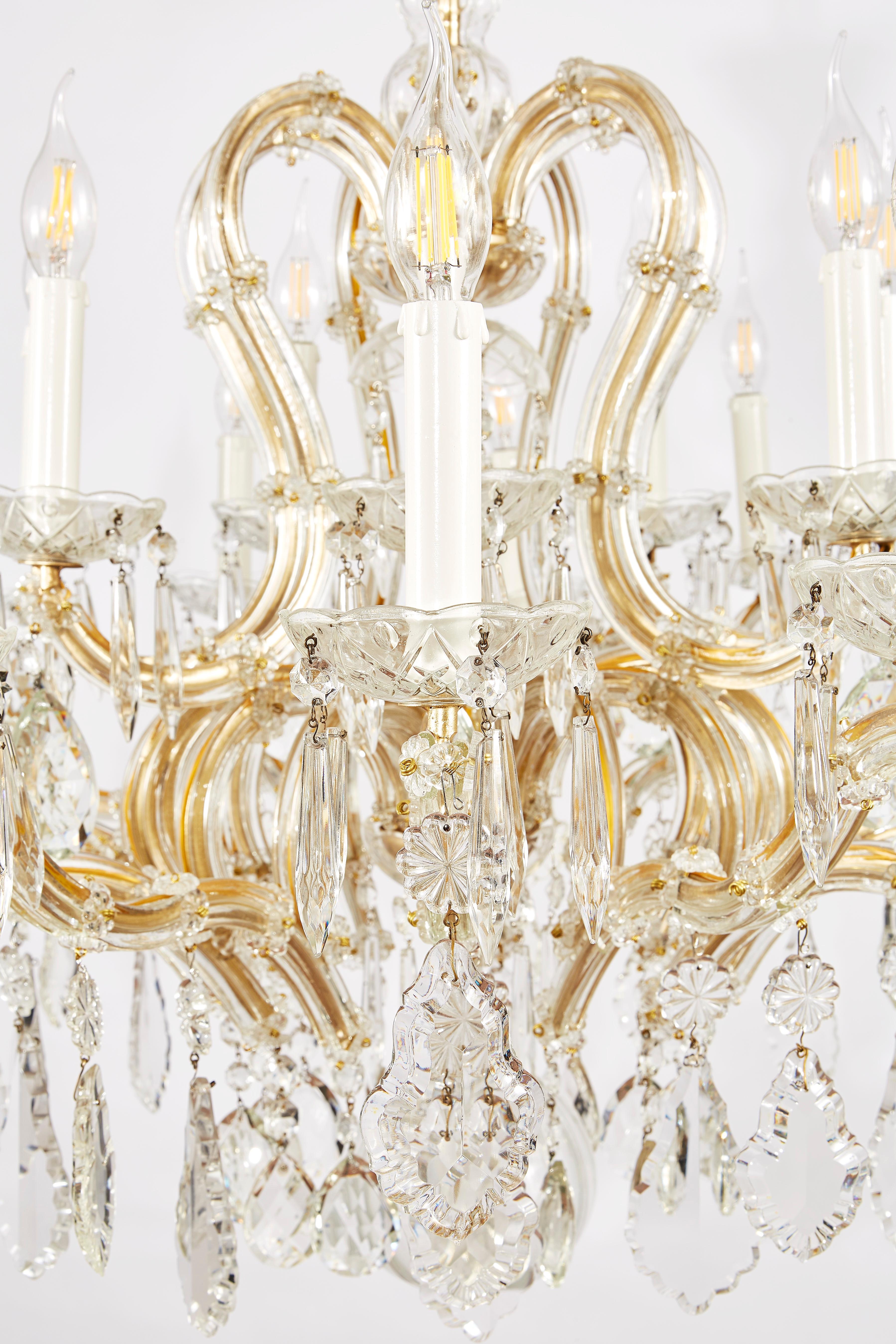 Gorgeous Italian Hollywood Regency style twenty two-light crystal chandelier with a large circular tree-shaped form surmounted by beautifully contoured scrolling arms. This lovely two-tier chandelier is in good condition and comes from a private