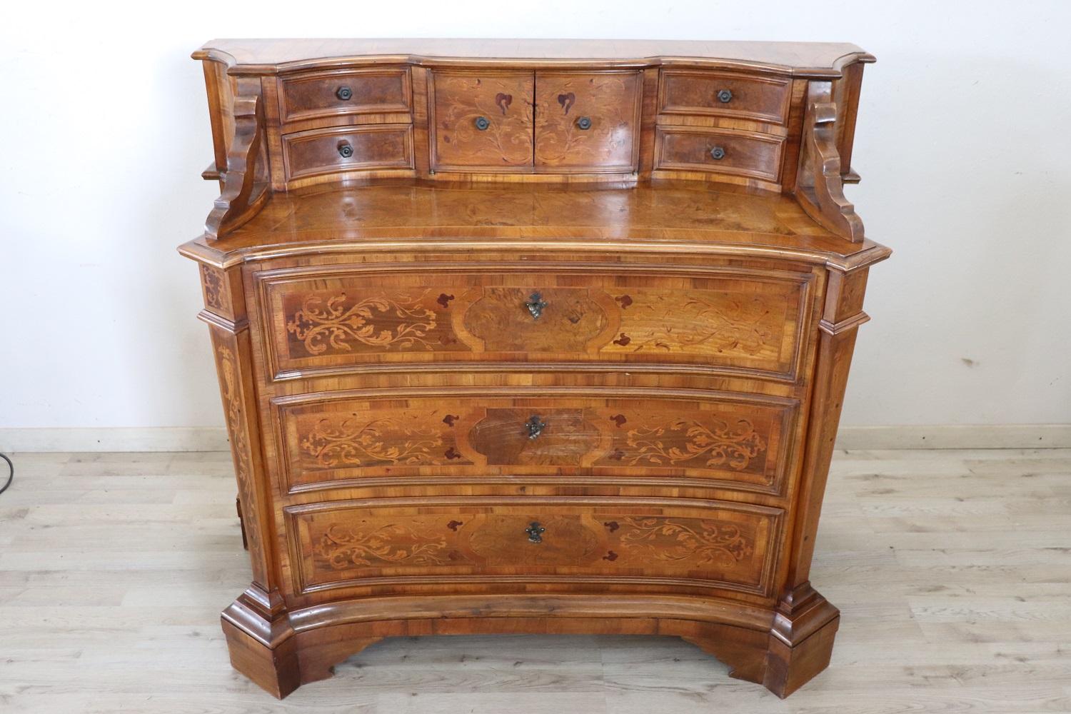 Louis XIV style italian furniture, 1950s. The fine walnut inlaid wood. Refined and rich inlay work of floral taste on each side of the piece of furniture. Particular rounded shape. On the front there are three comfortable large drawers. On the top a