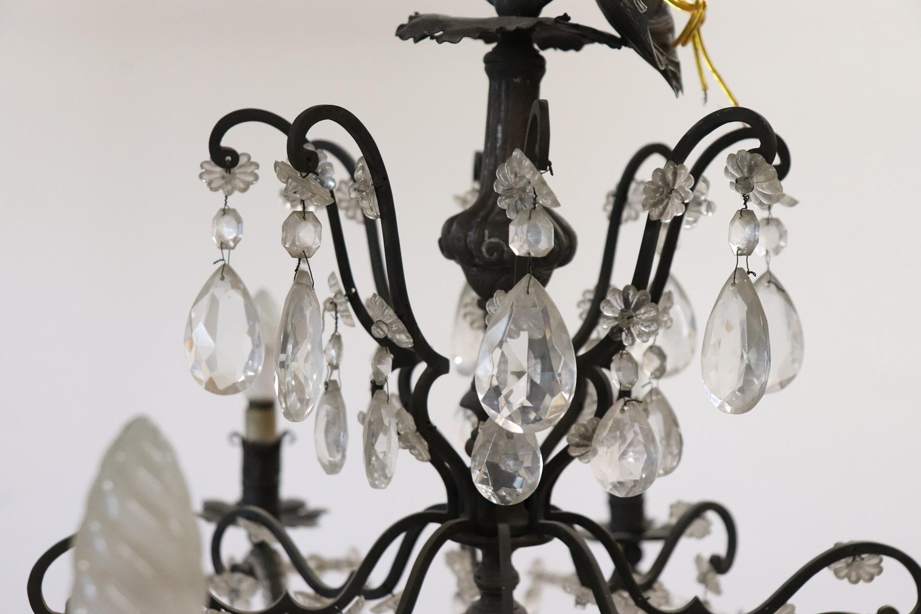 Beautiful and refined Italian Louis XVI style, circa 1940s chandelier eight lights. In patinated bronze and completely covered drops of crystal Swarovski. The arms are completely covered with small crystals. The crystal exudes the typical